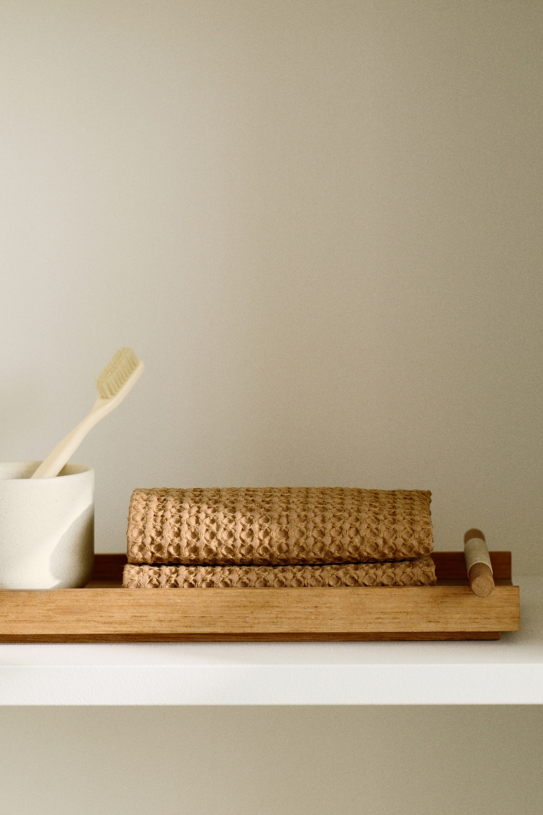 Visualizza immagine più grande: Due asciugamani ospiti vengono presentati, piegati e impilati, ciascuno caratterizzato da una morbida texture in cotone a nido d'ape color naturale beige.