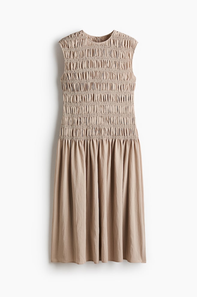 "The beige sleeveless dress is shown in a front view, with its bodice fully smocked from the round neckline down to a gathered waistline, transitioning into a flowing A-line skirt." - 1
