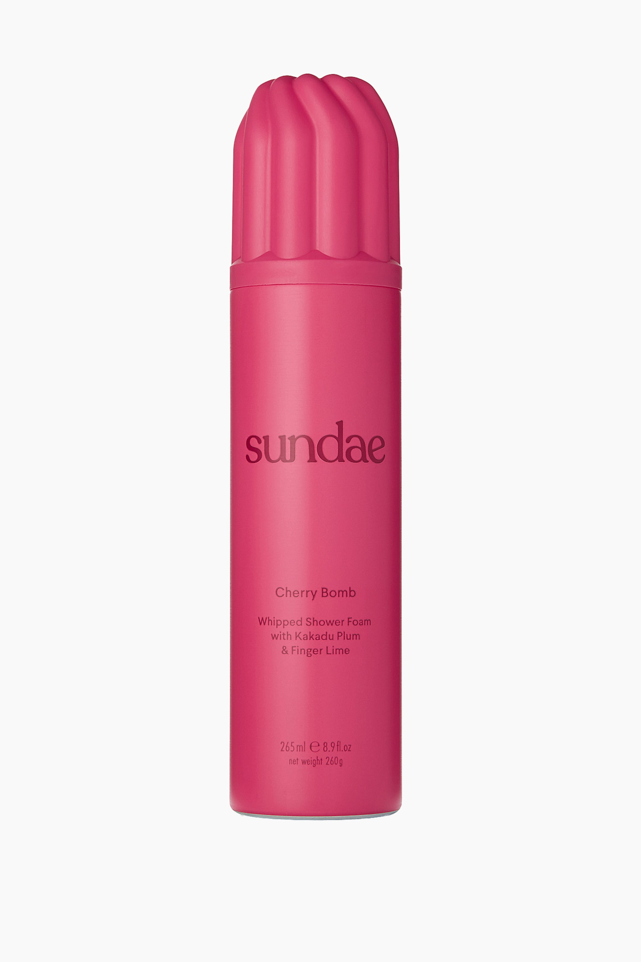 Vis større bilde: En forfra-vinkel av en sylindrisk, knallrosa boks med Sundae Whipped Shower Foam viser et matchende rosa lokk formet som pisket krem med vertikale, avrundede riller. Forsiden av boksen viser merkenavnet «sundae» i mørk rosa, etterfulgt av «Cherry Bomb» og produktdetaljer trykt nedenfor.