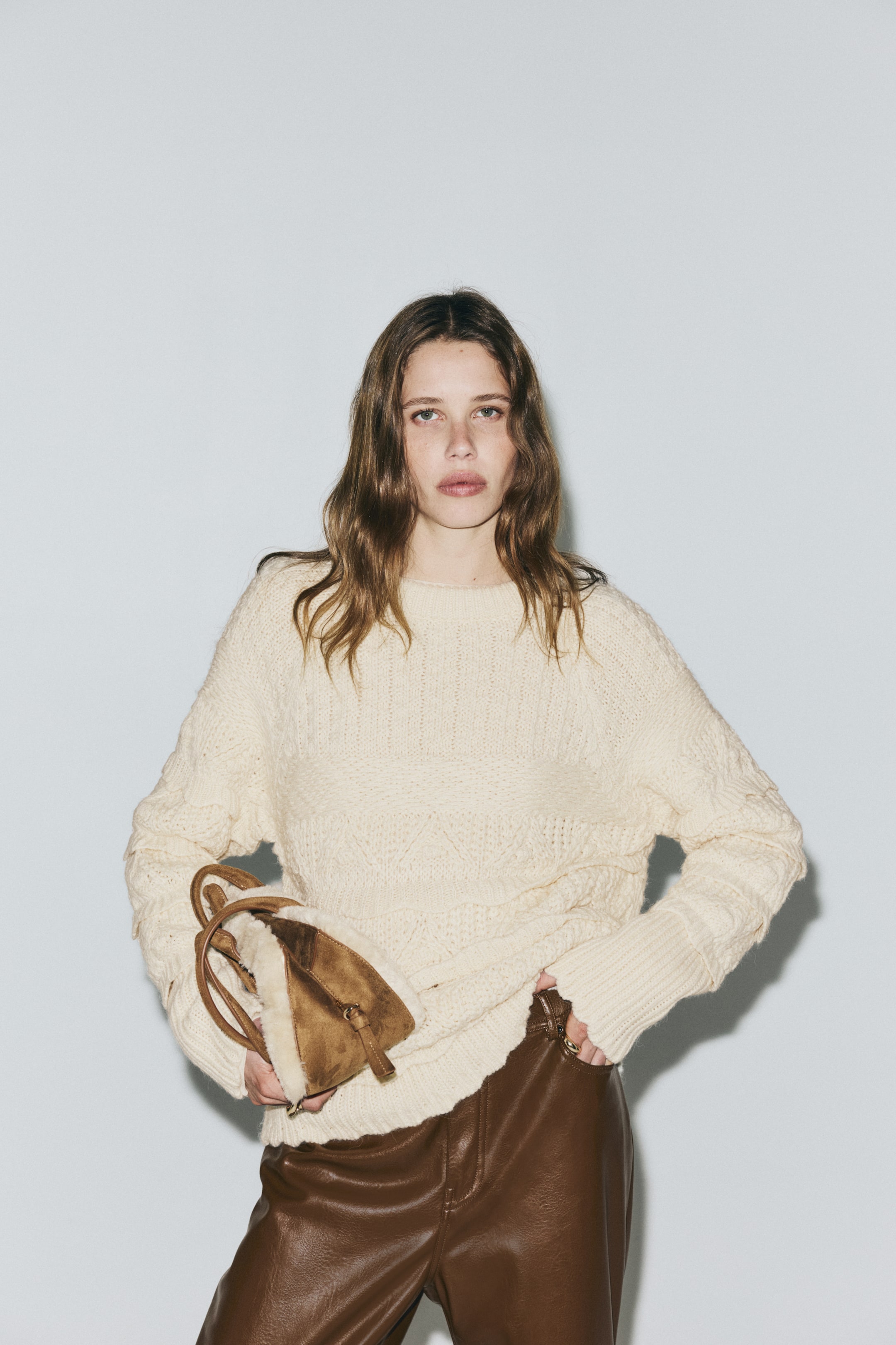 Visa större bild: En krämfärgad tröja presenteras som FRONT, som har en mjuk, texturerad stickning med volangdetaljer på ärmarna. Den visar upp en rund, ribbad halsringning, långa raglanärmar och ribbade muddar och fåll med kantskurna kanter.