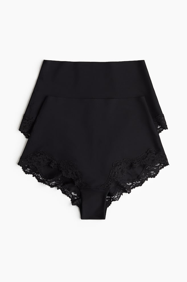 Zwei Paar schwarze, hüfthohe Slips sind ausgelegt und zeigen ihre VORDERSEITE. Jeder Slip ist aus weicher Mikrofaser gefertigt und verfügt über eine laser-geschnittene obere Kante sowie mit Spitze besetzte Beinöffnungen. - 1