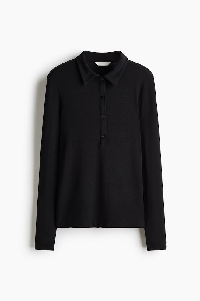 Ein langes, figurbetontes schwarzes Poloshirt aus Stretch-Jersey ist von vorne zu sehen und verfügt über einen klassischen Kragen, eine vertikale Vier-Knopf-Leiste und extralange Ãrmel. - 1