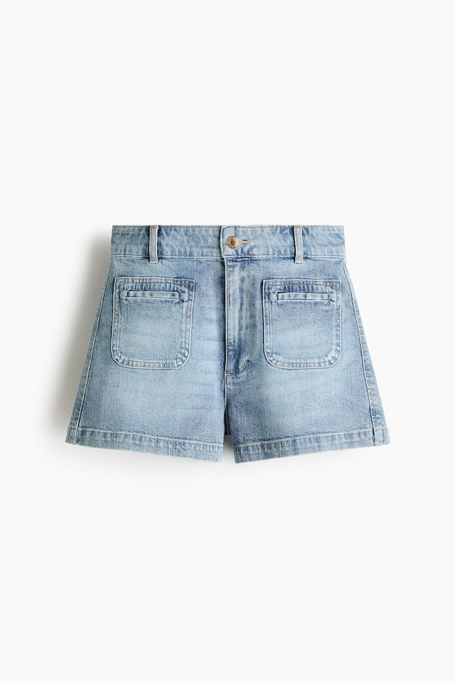 Light wash denim shorts are showcasing a front view, boasting a high waist with belt loops, a zip fly, and a button fastening. Two patch front pockets with horizontal welt openings are detailing the front. - 1