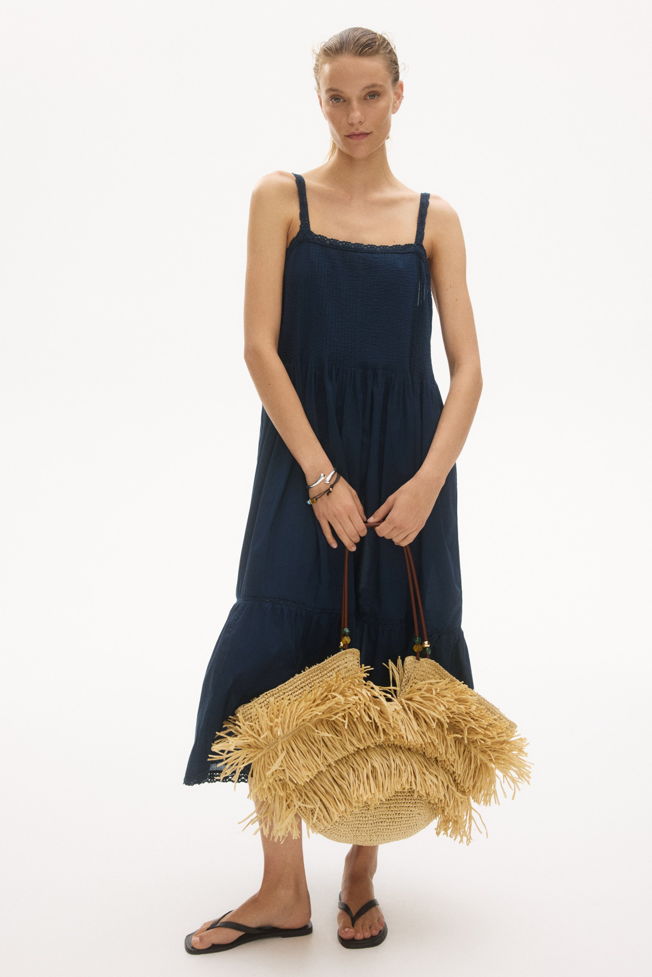 Voir une image plus grande: Une robe bleu foncé, longueur mi-mollet, en coton léger est présentée de face. Elle se distingue par un décolleté carré avec des bordures en dentelle et des bretelles en dentelle, un corsage smocké, une jupe légèrement évasée et un volant froncé avec un insert en dentelle au-dessus de l'ourlet.