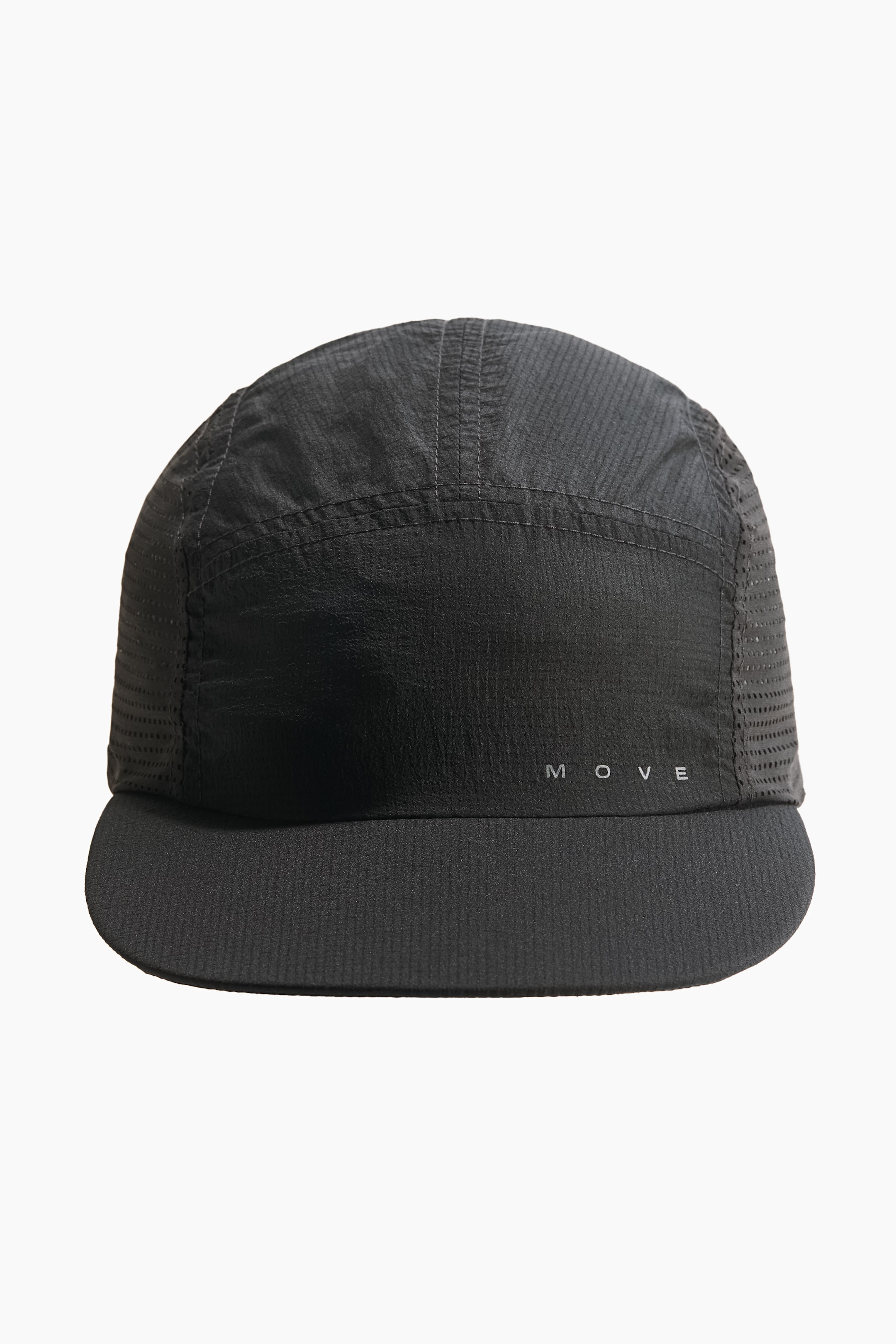 View larger image: A black 5-panel cap is oriented forward, showcasing a textured fabric crown with visible stitching and perforated mesh side panels. The flat brim exhibits a ribbed texture, with the word "M O V E" printed in light grey on the front.