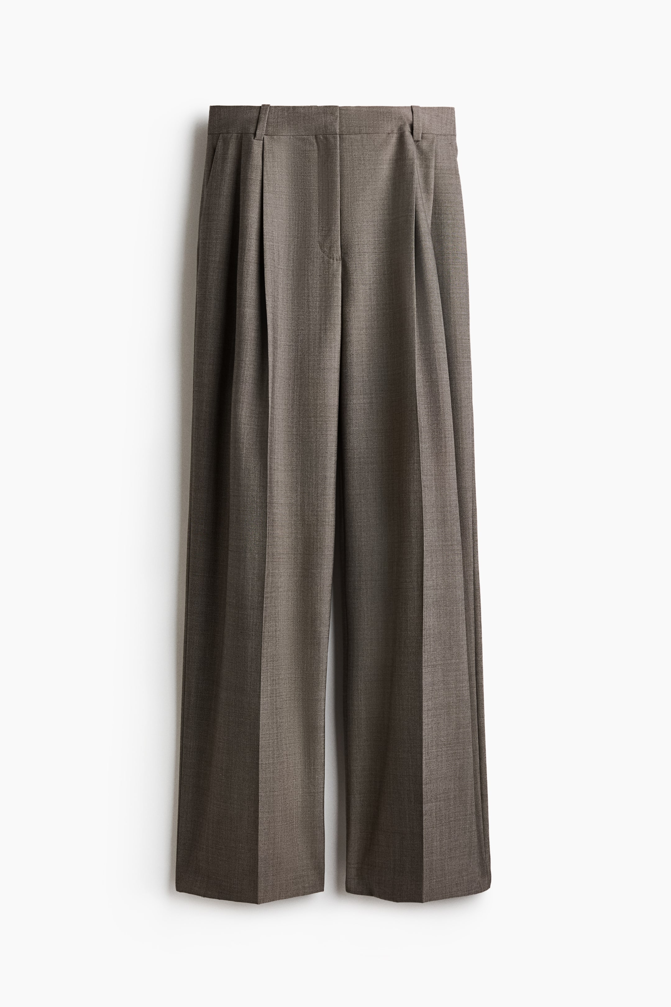 Agrandir l'image: Un pantalon large en tissu texturé taupe-brun est présenté de face, mettant en valeur une ceinture structurée avec passants pour ceinture et une fermeture frontale dissimulée. Le pantalon présente de grands plis sur le devant ainsi que des plis marqués et repassés qui descendent au centre de chaque jambe large.