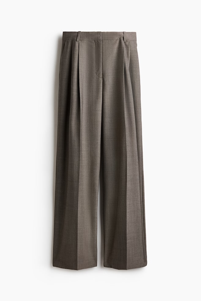 Eine weit geschnittene Hose aus strukturiertem taupebraunem Stoff ist von vorne zu sehen und zeigt einen formgeschnittenen Bund mit GÃ¼rtelschlaufen und verdecktem Frontverschluss. Die Hose prÃ¤sentiert tiefe Bundfalten vorn sowie scharfe BÃ¼gelfalten, die mittig Ã¼ber jedes weite Hosenbein verlaufen. - 1