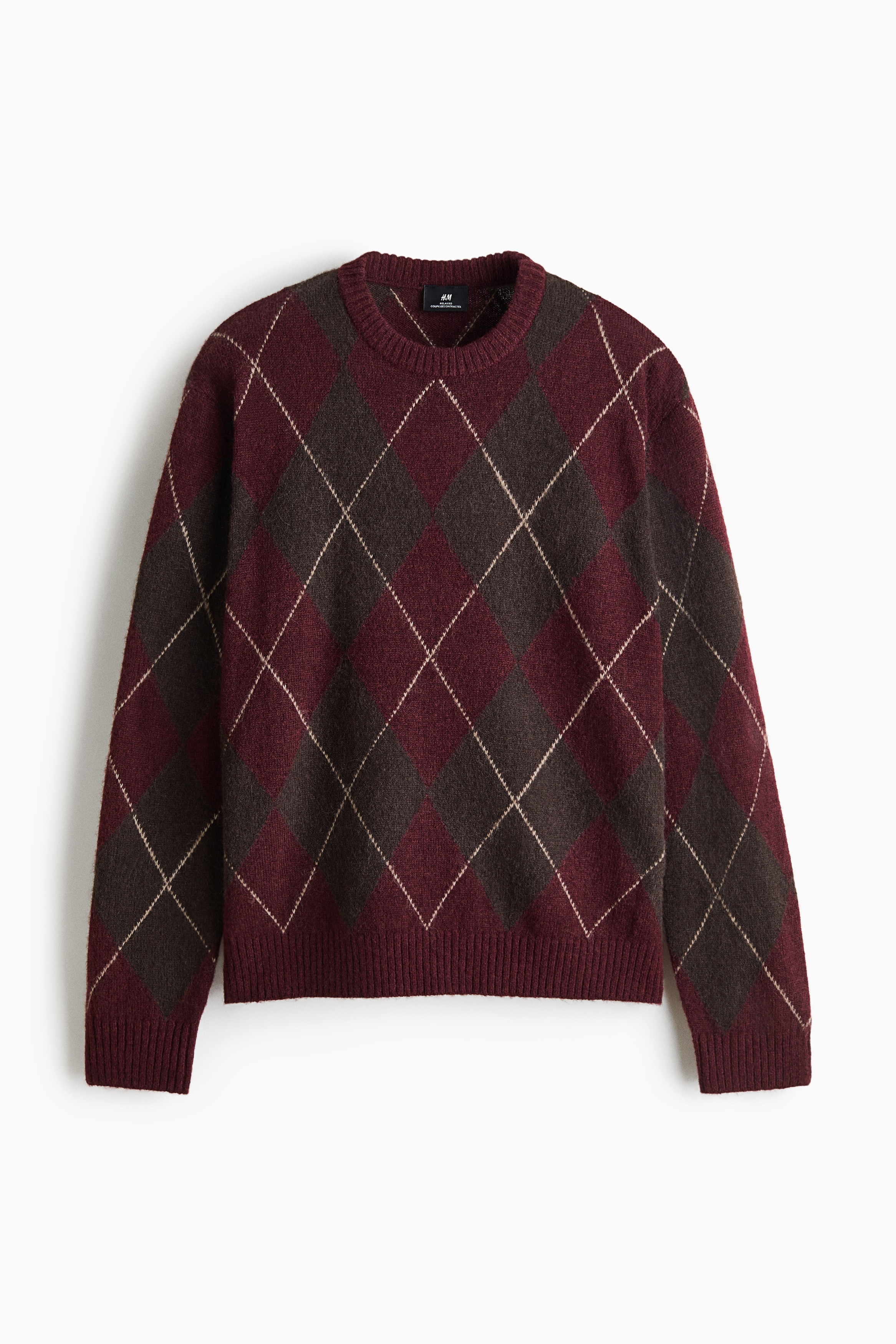 A front-facing long-sleeved knit sweater is displaying a classic argyle pattern in shades of burgundy and dark brown with thin, beige intersecting lines. The sweater is featuring a ribbed crew neck, ribbed cuffs, and a ribbed hem.