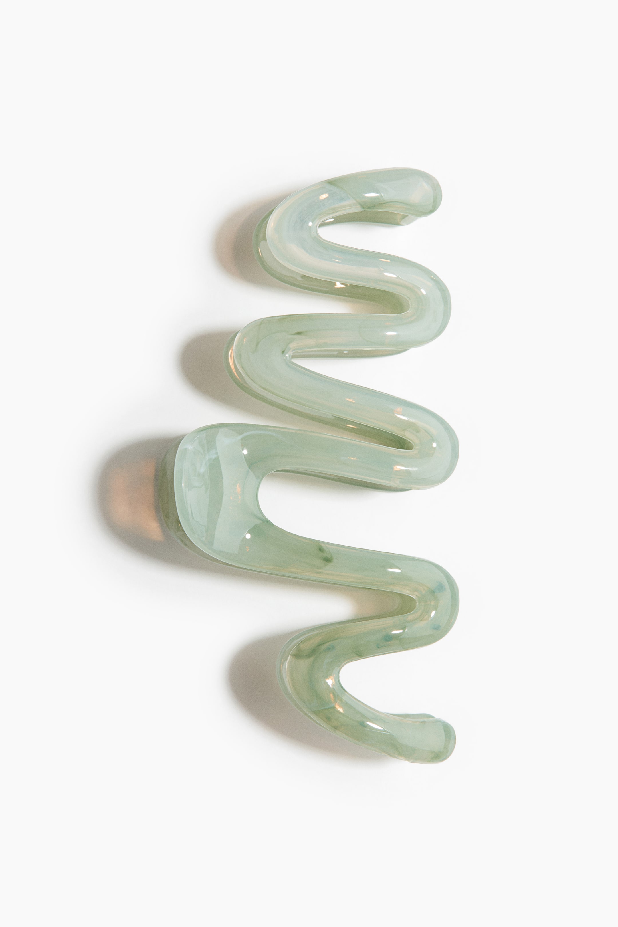 Se større billede: Et serpentinformet, bølget objekt fremviser translucent, lysegrønt glas med mælkehvide hvirvler, der præsenterer en glat, blank overflade og en kontinuerlig bølgende form.