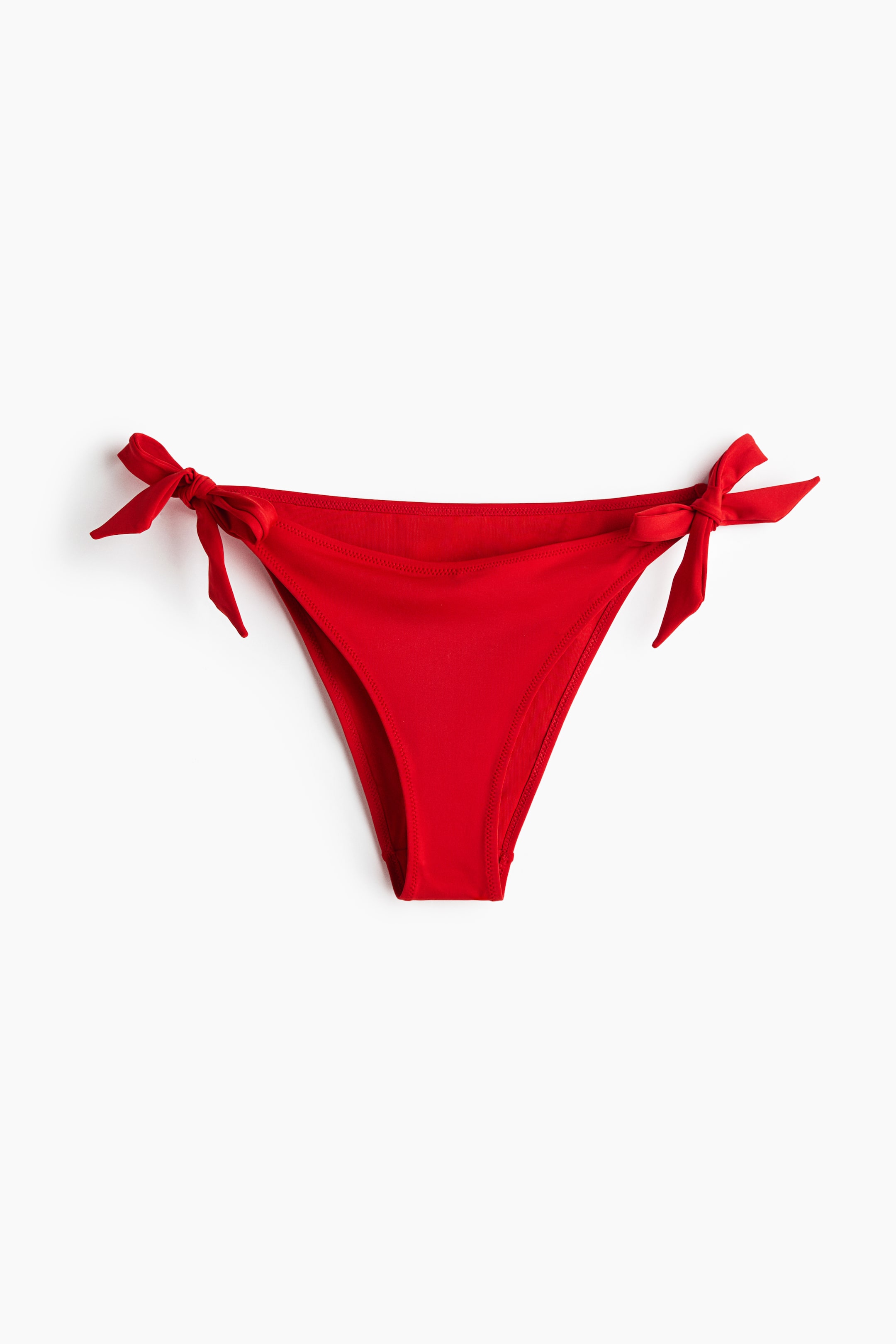 View larger image: A red bikini bottom is shown from the front, highlighting a V-shaped waist and ties that form bows on each side.