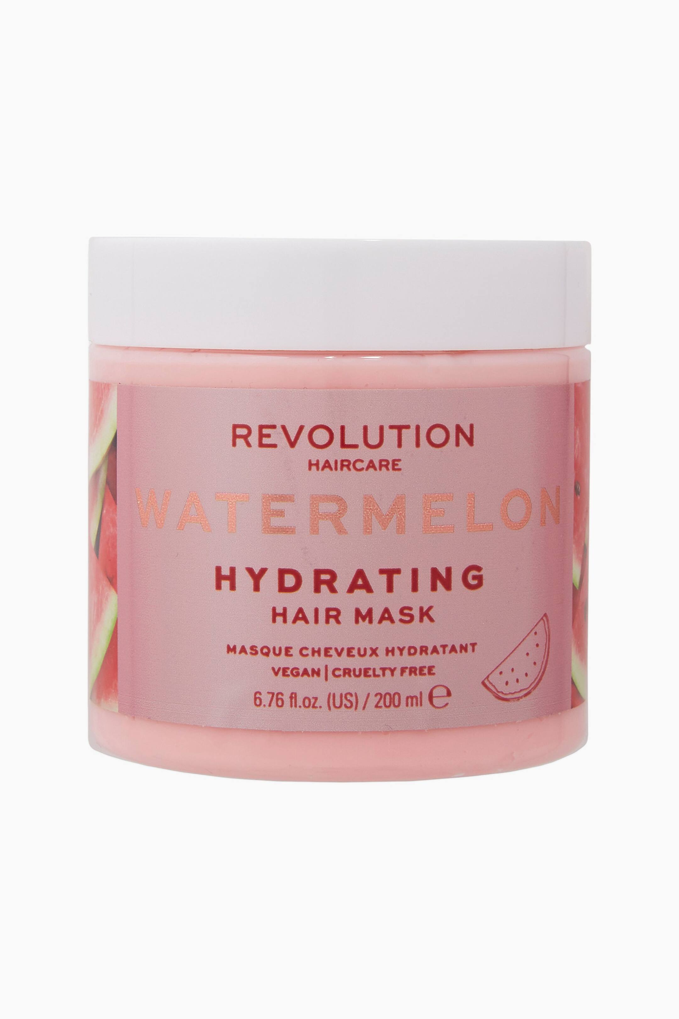 Visa större bild: Revolution Haircare Watermelon Hydrating Hair Mask står upprätt i en frontvänd vy och har en cylindrisk ljusrosa burk med ett helvitt skruvlock. En rosa etikett omsluter burkens mitt och visar varumärkeslogotypen, "WATERMELON" i stora metalliskt rosa bokstäver samt "HYDRATING HAIR MASK" i fet röd text tillsammans med illustrationer av vattenmelonskivor.