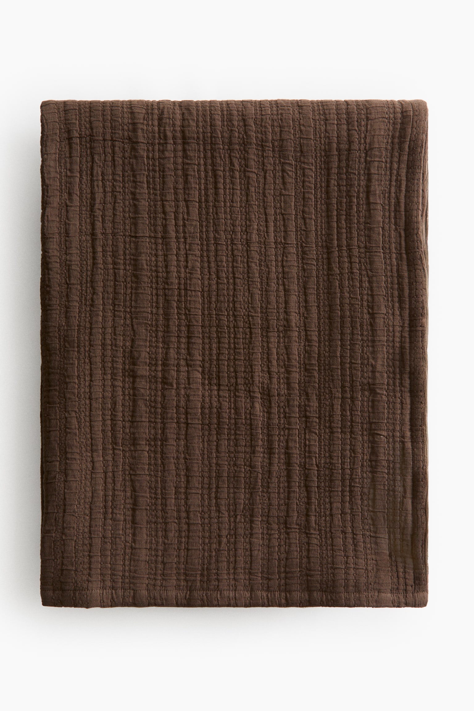 The single bedspread showcases a rich brown hue. It boasts a soft, crinkled cotton muslin weave, with delicate vertical lines subtly visible across its surface. - 1