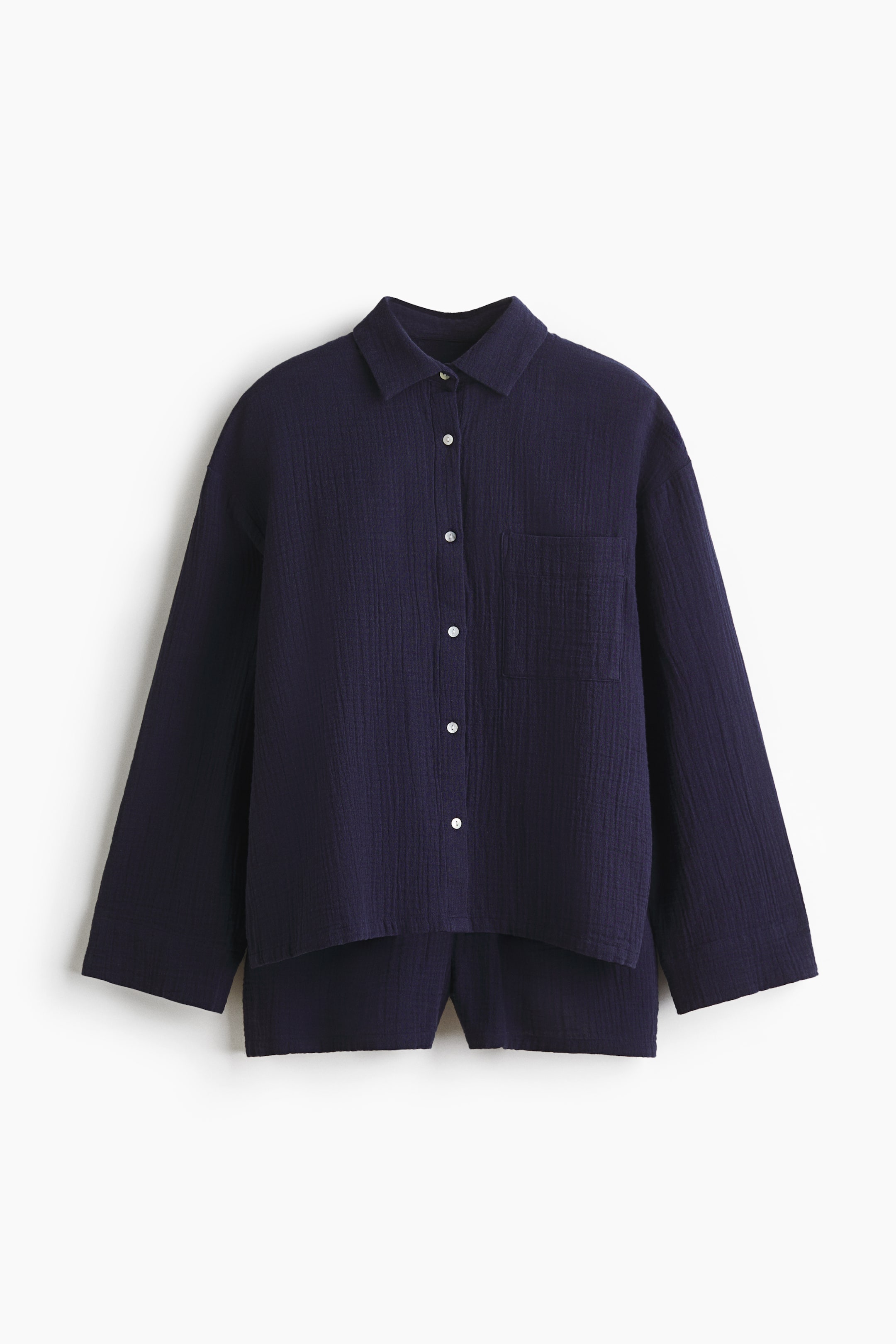 Agrandir l'image: Un ensemble de pyjama bleu marine, confectionné en doux coton mousseline, est composé d'une chemise à manches longues et d'un short, présenté de face. La chemise arbore un col, des boutons blancs sur le devant et une poche poitrine plaquée ; le short est conçu avec une taille élastiquée et un cordon de serrage.