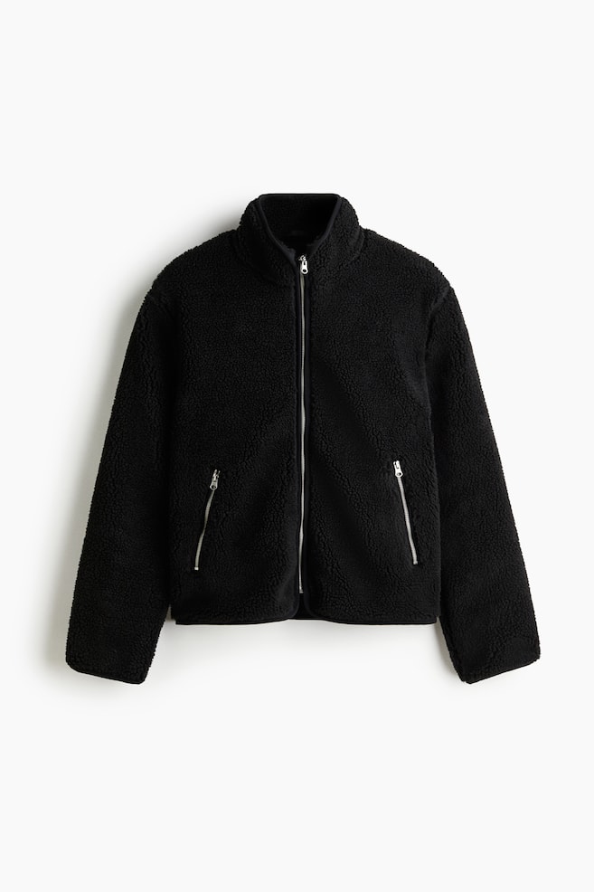 A black teddy fleece jacket is shown from the front, featuring a full-zip closure with a silver-toned zipper, a stand-up collar, and two angled, silver-toned zippered pockets on the front. - 1
