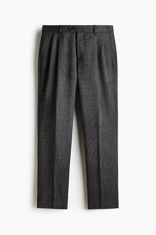 The dark grey, textured trousers are facing front, featuring a waistband with belt loops and a single button closure. The straight-cut legs are displaying front pleats and sharp, pressed center creases. - 1