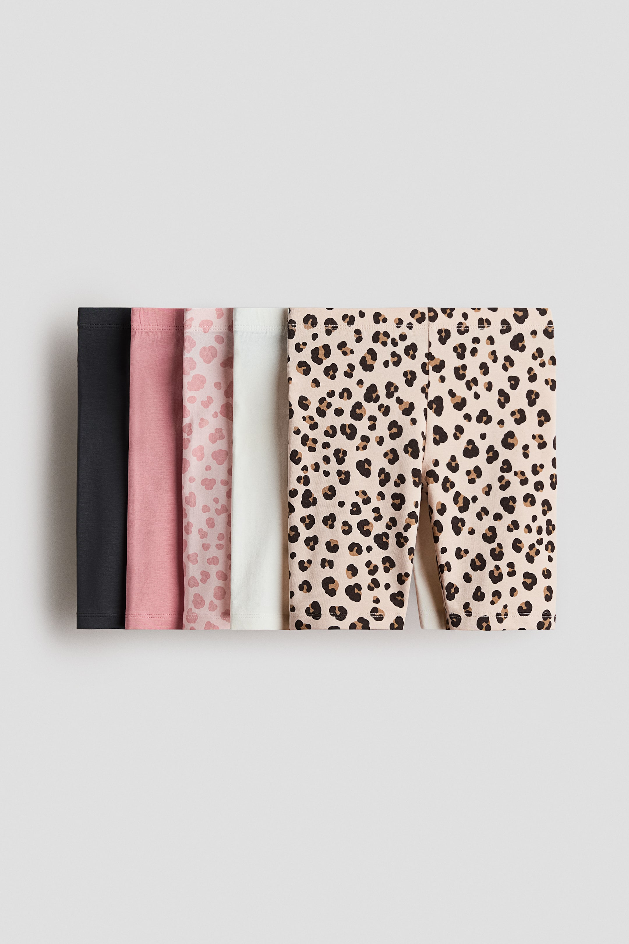 View larger image: Cycling shorts crafted from soft cotton jersey, featuring an elasticated waistband, are showcased front-facing in a set of five. This collection includes pairs in black, dusty pink, light pink adorned with a heart pattern, white, and beige embellished with a leopard print.