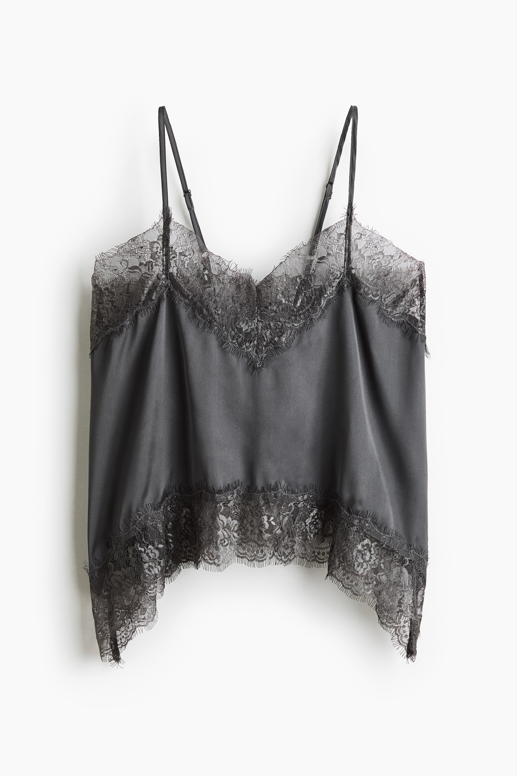 View larger image: A dark grey satin camisole top is hanging front-facing, featuring a V-neckline and thin, adjustable shoulder straps. The top is designed with delicate eyelash lace trimming the neckline and the curved hem, which falls longer at the sides.