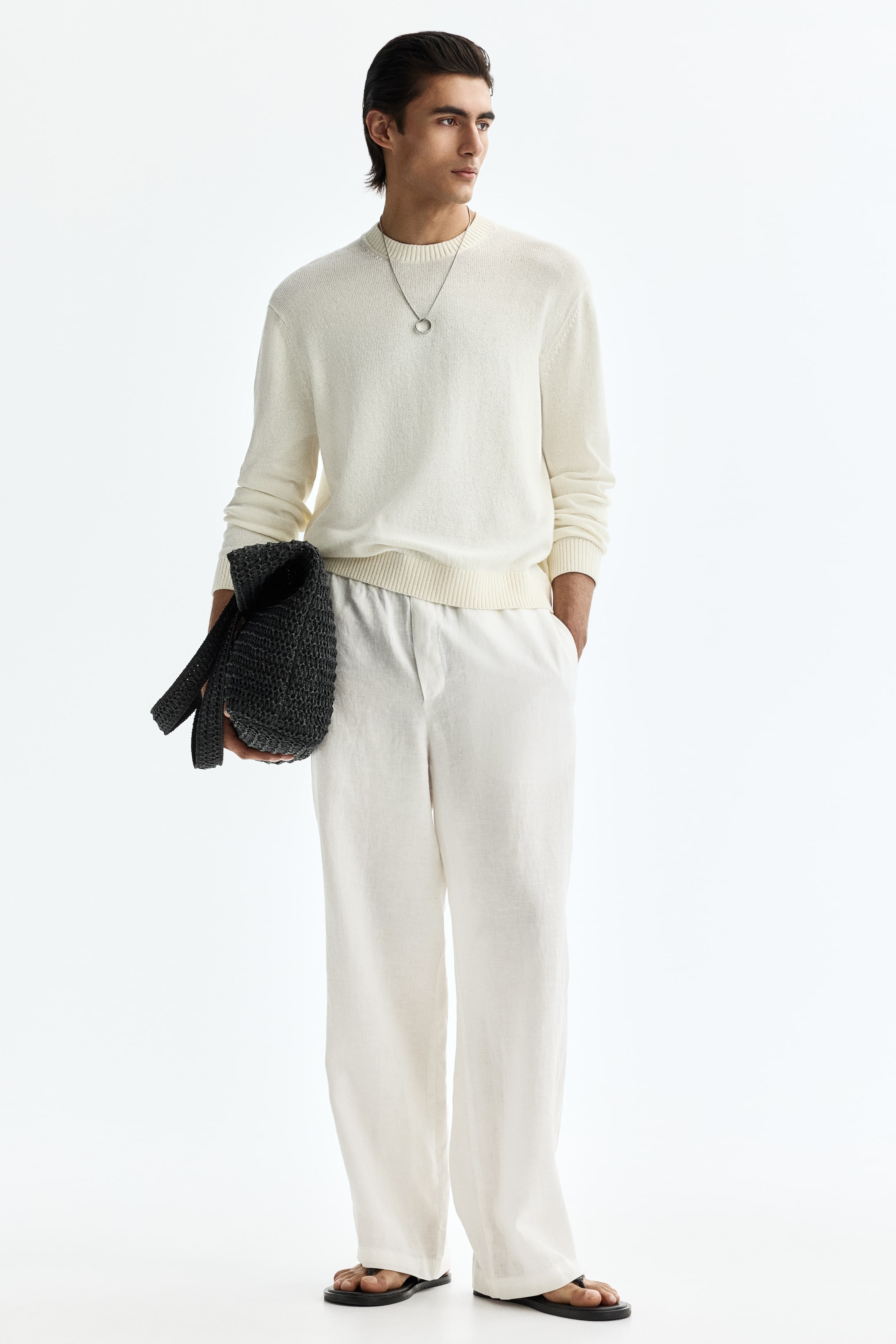 View larger image: The cream-coloured crew neck sweater boasts a relaxed fit, complete with long sleeves, ribbed cuffs, and a ribbed hem, while a circular pendant necklace elegantly adorns its neckline.