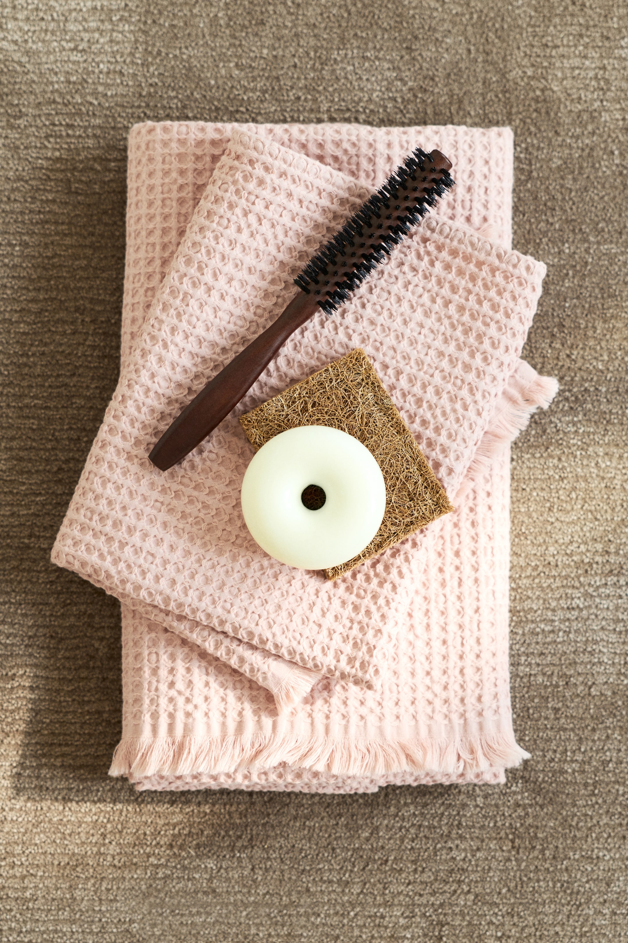 이미지 확대 보기: 와플 직조 면 소재의 분홍색 손수건입니다. 짧은 가장자리에 술 장식이 있으며 접혀 있습니다.