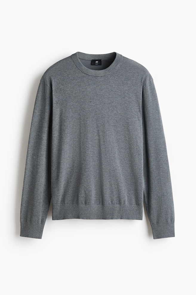 A marl grey crewneck jumper is shown front-facing, featuring a fine knit texture with ribbed cuffs and a ribbed hem. - 1