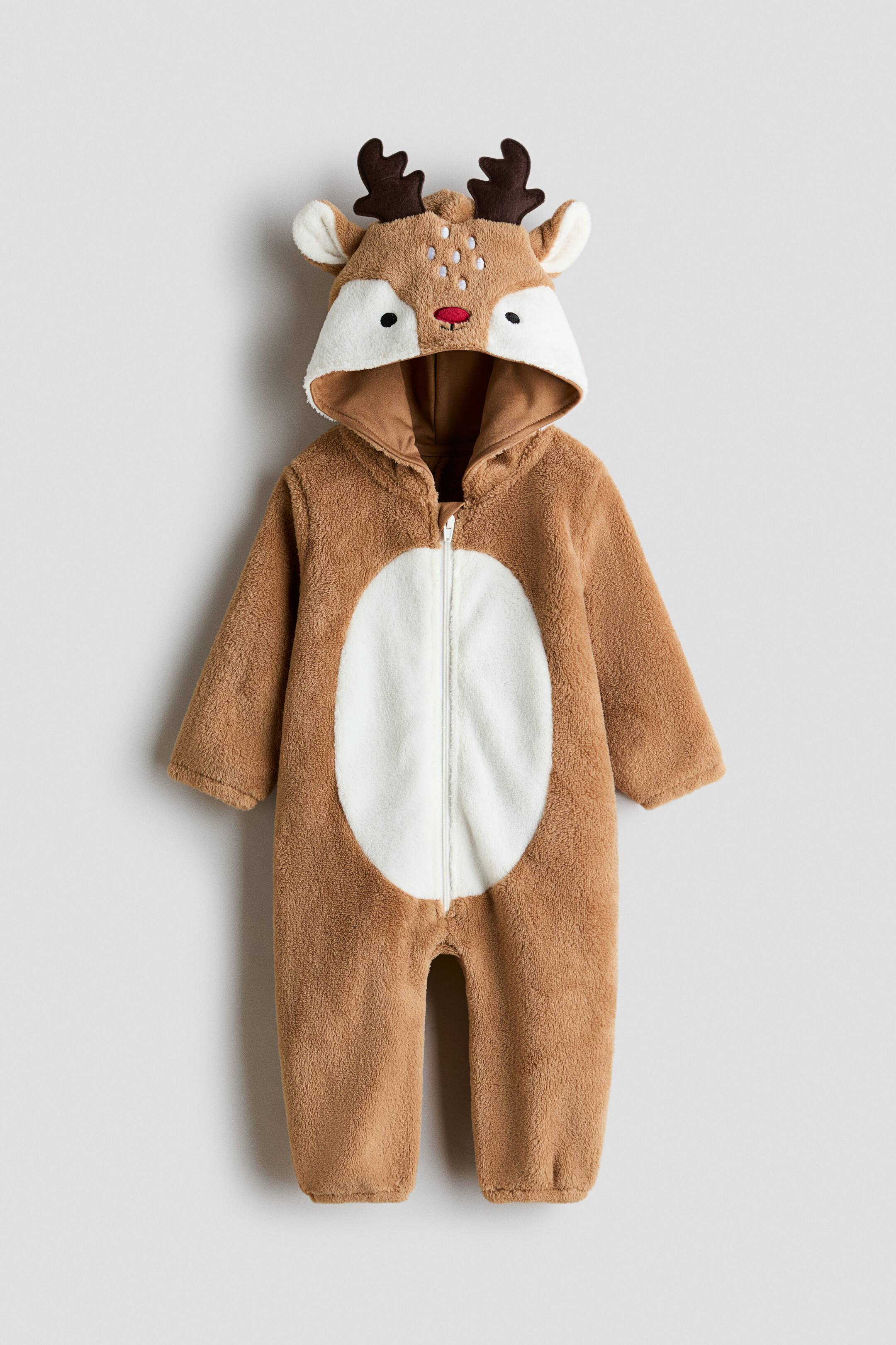 Grotere afbeelding bekijken: Een rendier verkleedkostuum is van voren afgebeeld en toont een bruin, zacht fleece lichaam met een contrasterende witte, ronde buikpatch en een centrale ritssluiting. De aangehechte capuchon heeft een rendiergezicht met geborduurde ogen en neus, zachte oren en donkerbruine gewei.