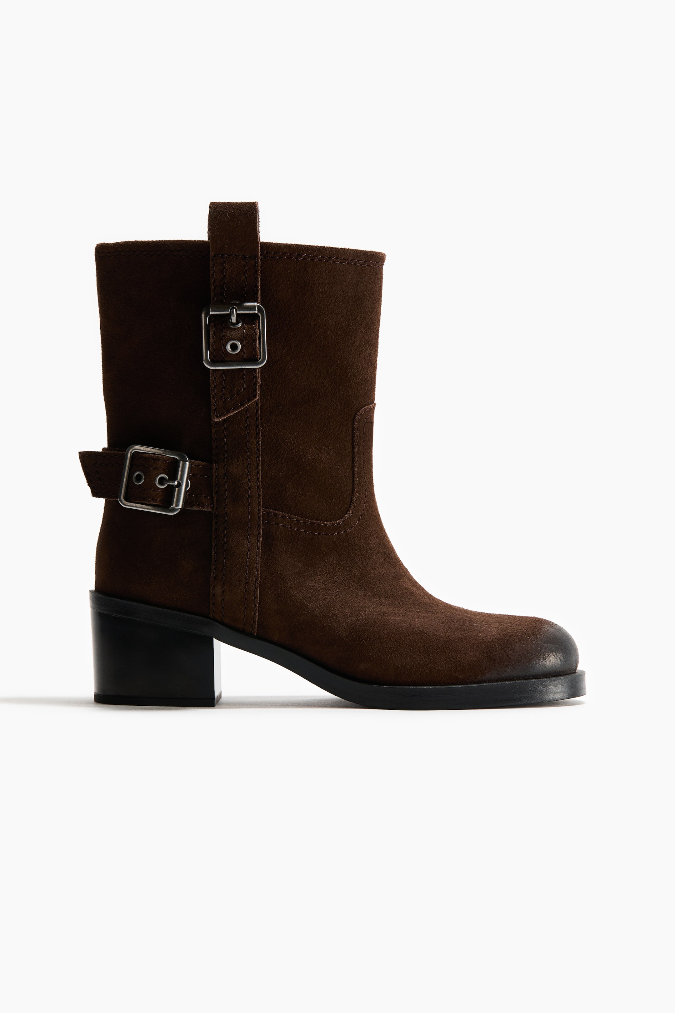 View larger image: A dark brown suede ankle boot is shown in side profile, facing right, featuring two silver-tone buckle straps on the shaft, a rounded toe, and a black block heel.