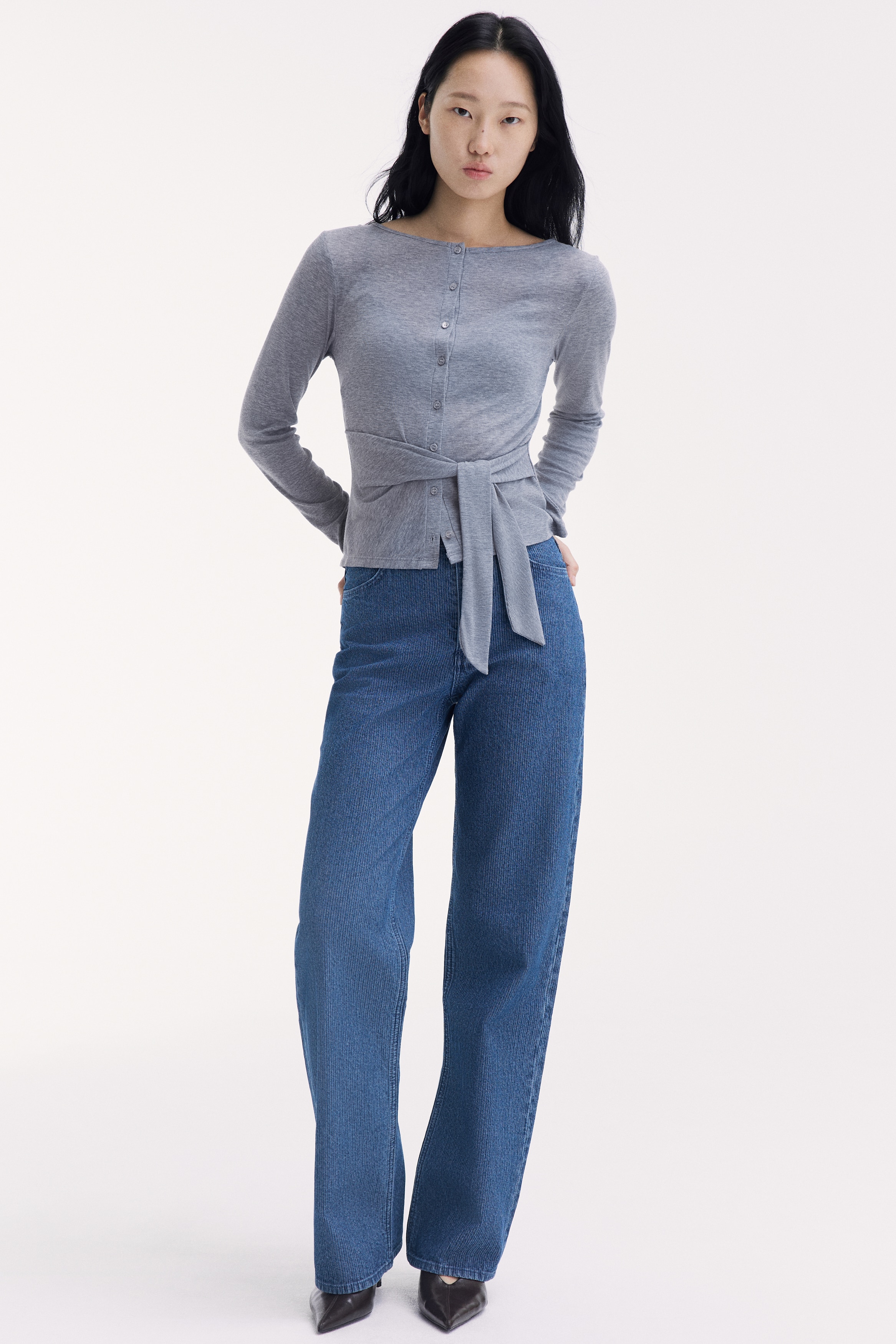 Chiáº¿c quáº§n jeans cáº¡p cao, á»ng rá»ng báº±ng denim xanh, cÃ³ há»a tiáº¿t sá»c dá»c, Äang ÄÆ°á»£c chá»¥p trá»±c diá»n. Thiáº¿t káº¿ ná»i báº­t vá»i khÃ³a cÃ i phÃ­a trÆ°á»c gá»m nÄm nÃºt, Äai Äeo tháº¯t lÆ°ng vÃ  tÃºi cong phÃ­a trÆ°á»c.
