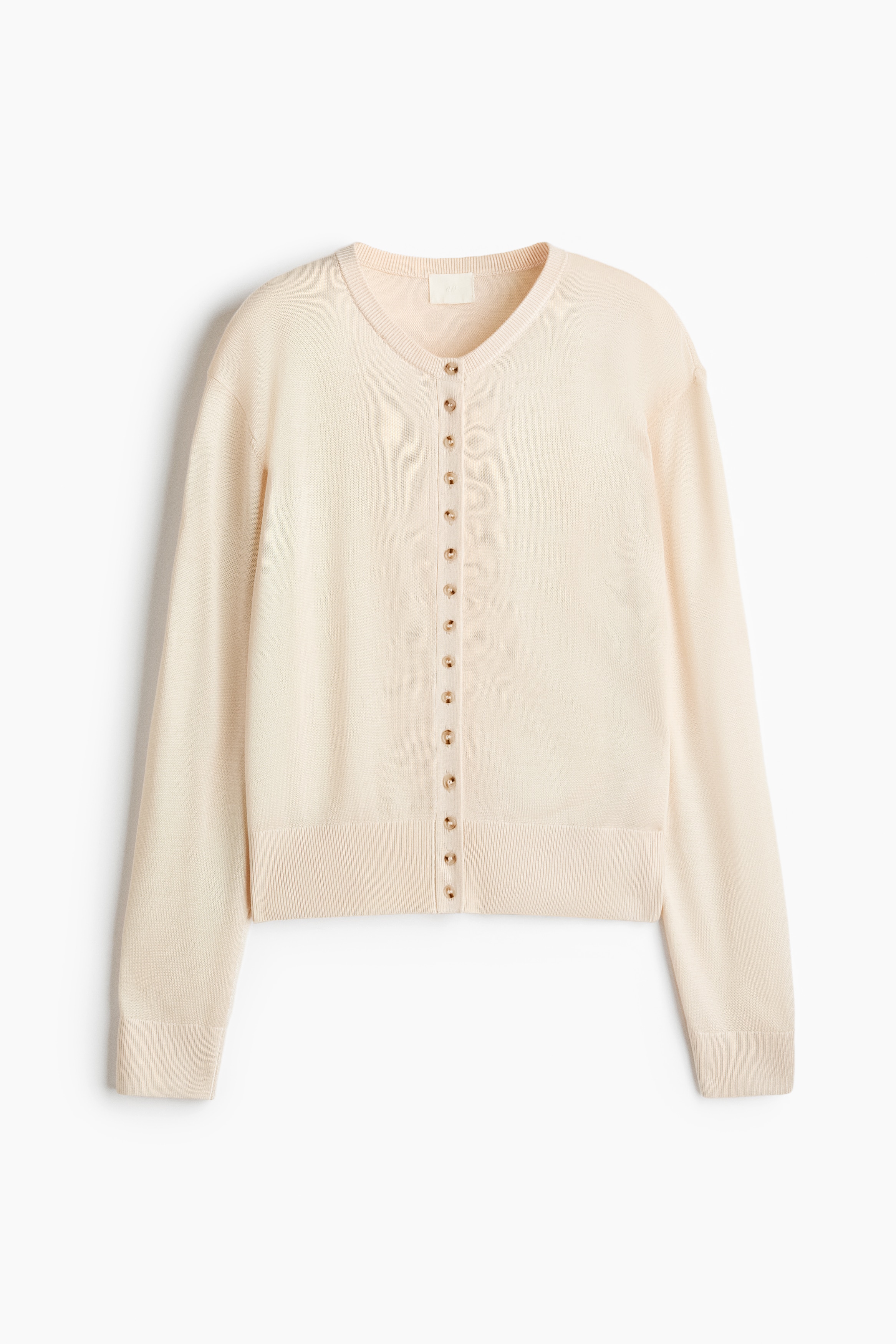 NgÆ°á»i máº«u Äang máº·c má»t chiáº¿c cardigan dá»t kim má»n mÃ u ÄÃ o nháº¡t, ÄÆ°á»£c phá»i vá»i pháº§n cÃºc trÃªn cÃ¹ng Äá» má» vÃ  sÆ¡ vin vÃ o má»t chiáº¿c chÃ¢n vÃ¡y mini Äen. Chiáº¿c cardigan cÃ³ cá» trÃ²n, hÃ ng cÃºc phÃ­a trÆ°á»c vÃ  tay dÃ i vá»i bo tay gÃ¢n.