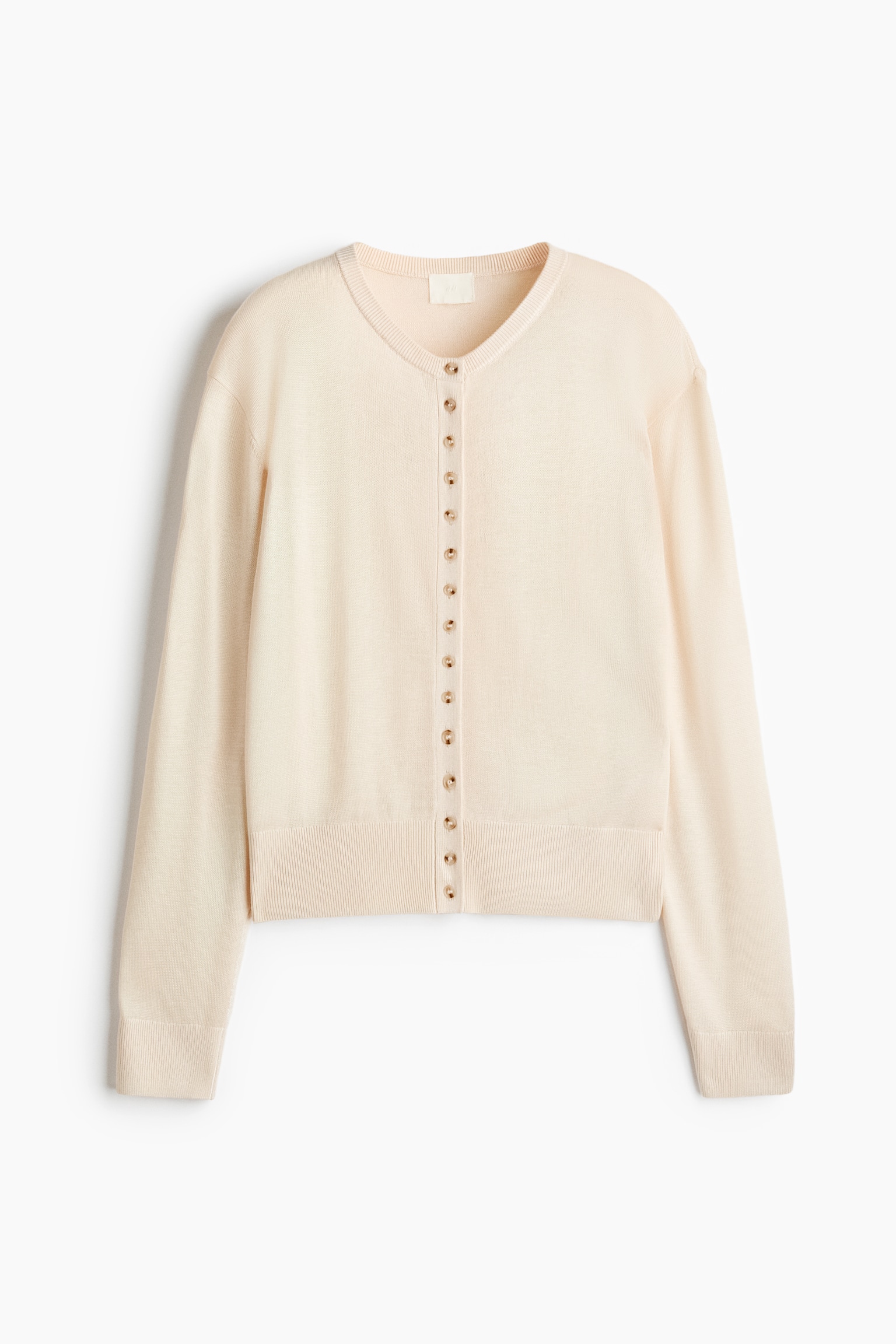 A cream cardigan is displayed flat, featuring a ribbed V-neckline and a full-length button placket. Small, round, light brown buttons are running down the front, and ribbed cuffs and a ribbed hem are completing the garment. - 1