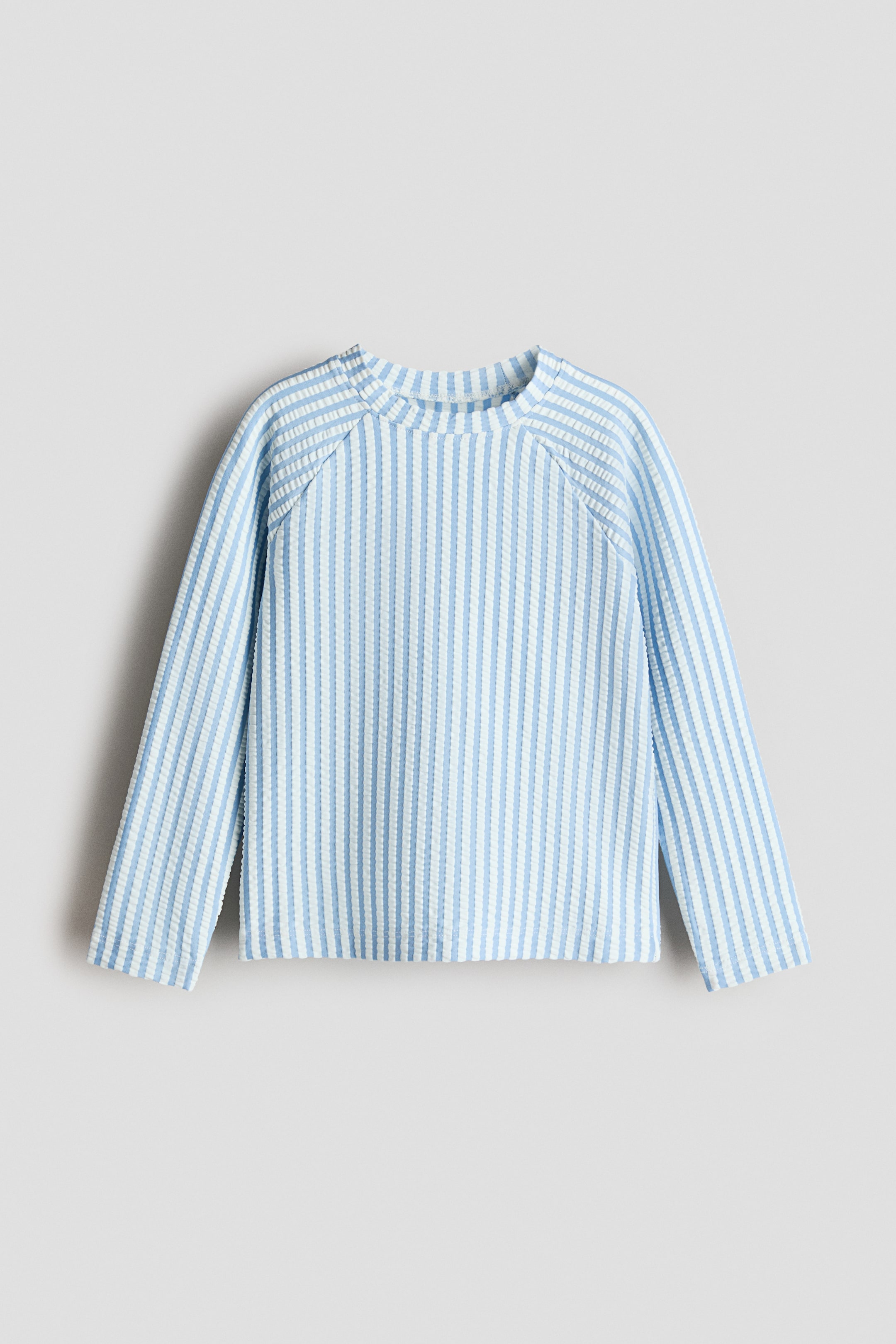 View larger image: A swim top is presented FRONT, featuring light blue and white vertical stripes.