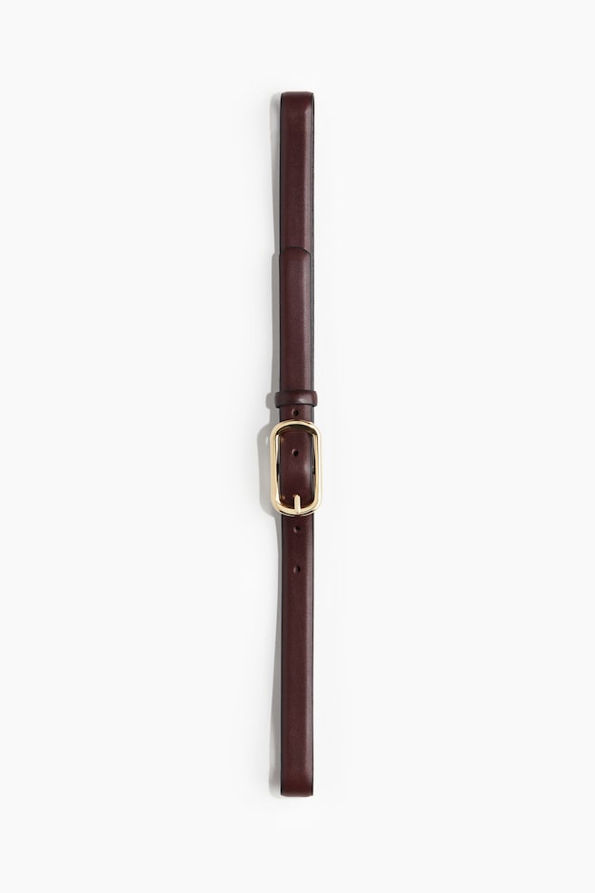 Une ceinture étroite en cuir marron, mesurant 2 cm de largeur, est posée à plat, avec une boucle ovale en métal doré. - 1