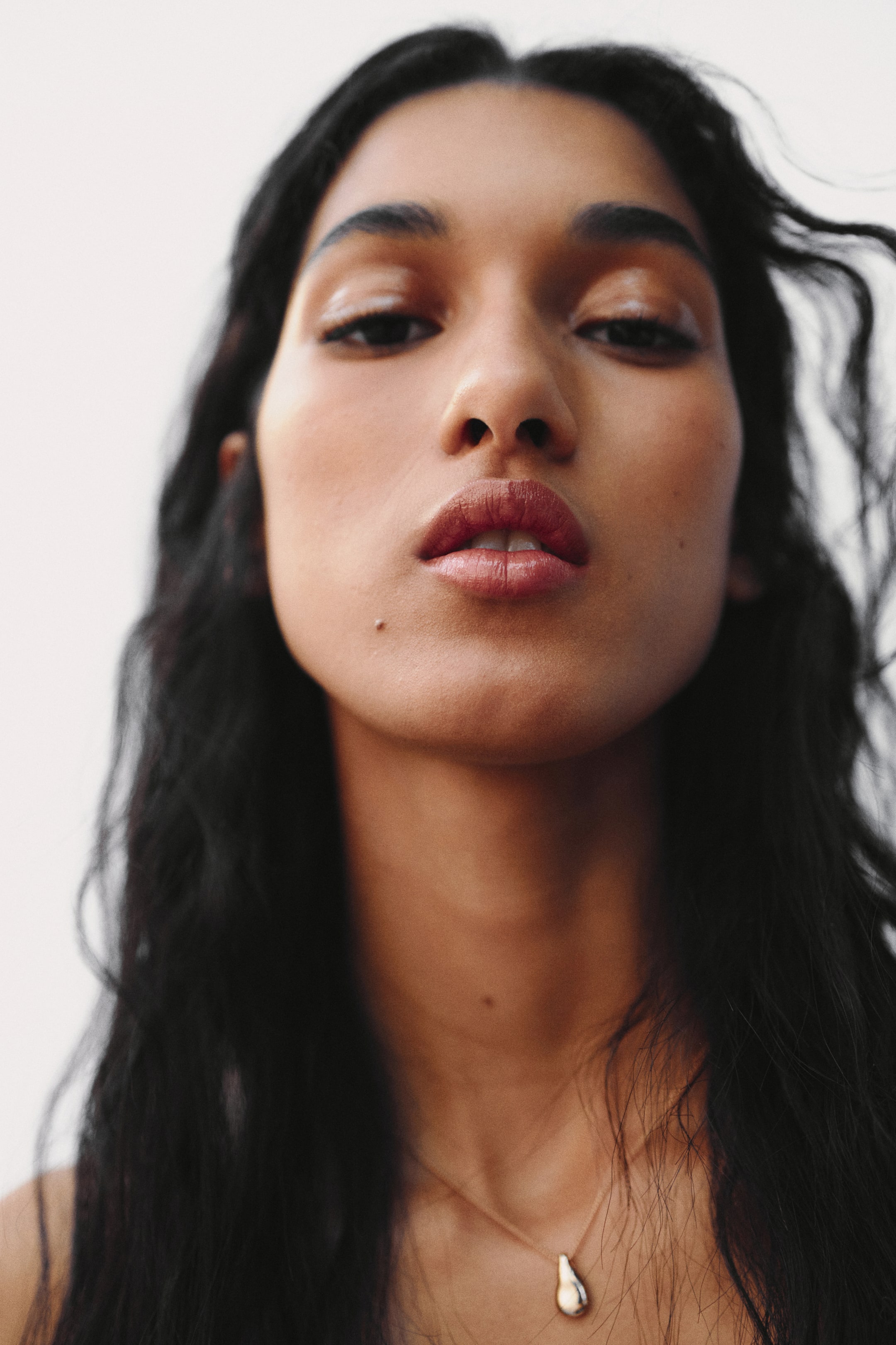 View larger image: A necklace features a small, polished, metallic, teardrop-shaped pendant hanging centrally from a delicate chain.