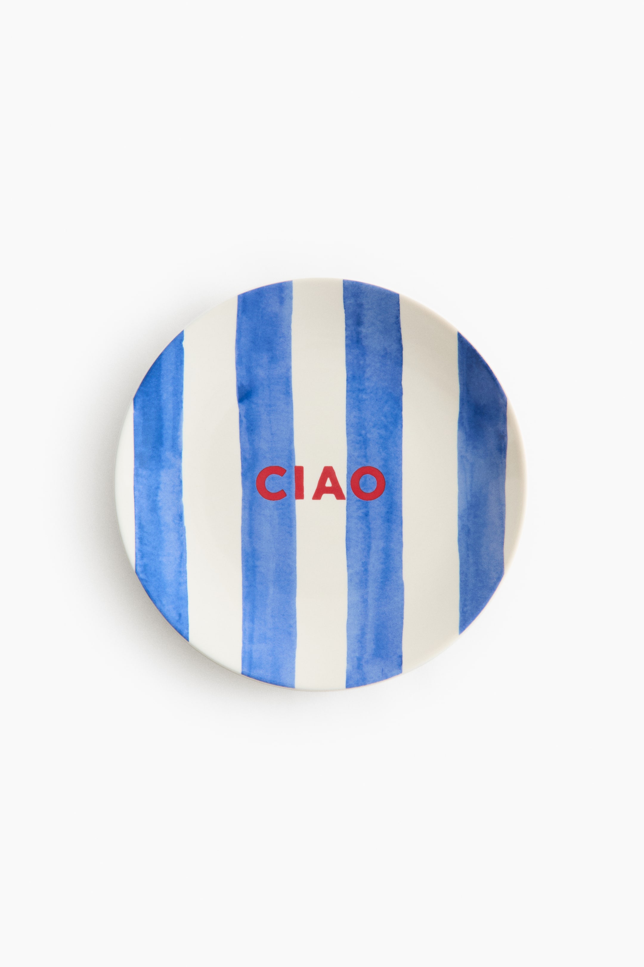 View larger image: A round porcelain plate features a hand-painted-style pattern of vertical blue and white stripes, shown from the front. The word "CIAO" is centred on the plate, appearing in bold red capital letters.