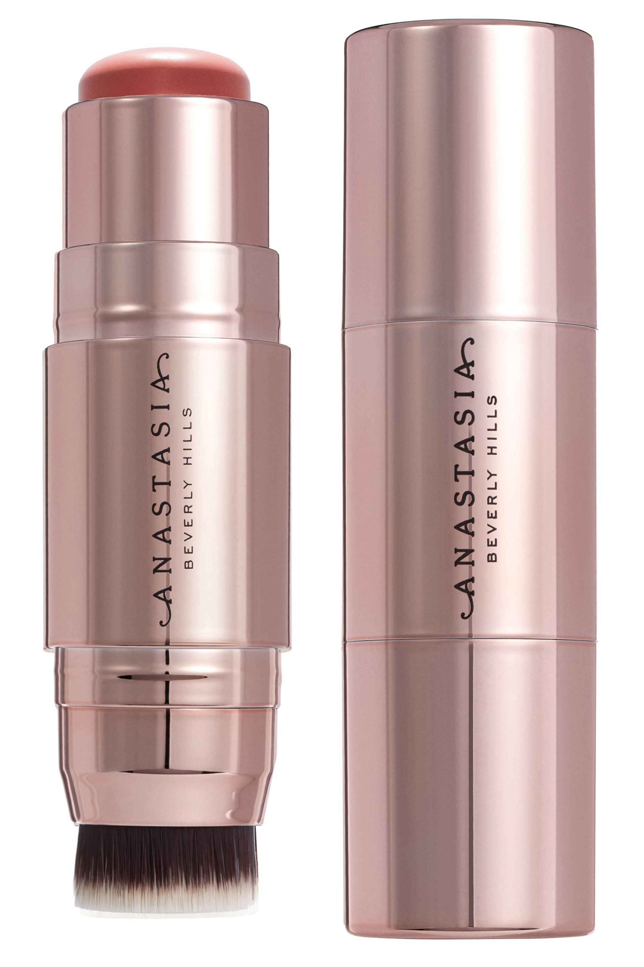 Vis større bilde: To sminkestifter i rosegull står oppreist, begge med 'ANASTASIA BEVERLY HILLS'-merke. Den ene stiften er åpen og avslører et avrundet, ferskenrosa produkt på toppen og en mørk brun til hvit tofarget børste ved basen, mens den andre stiften er lukket med et glatt, sylindrisk hylster.
