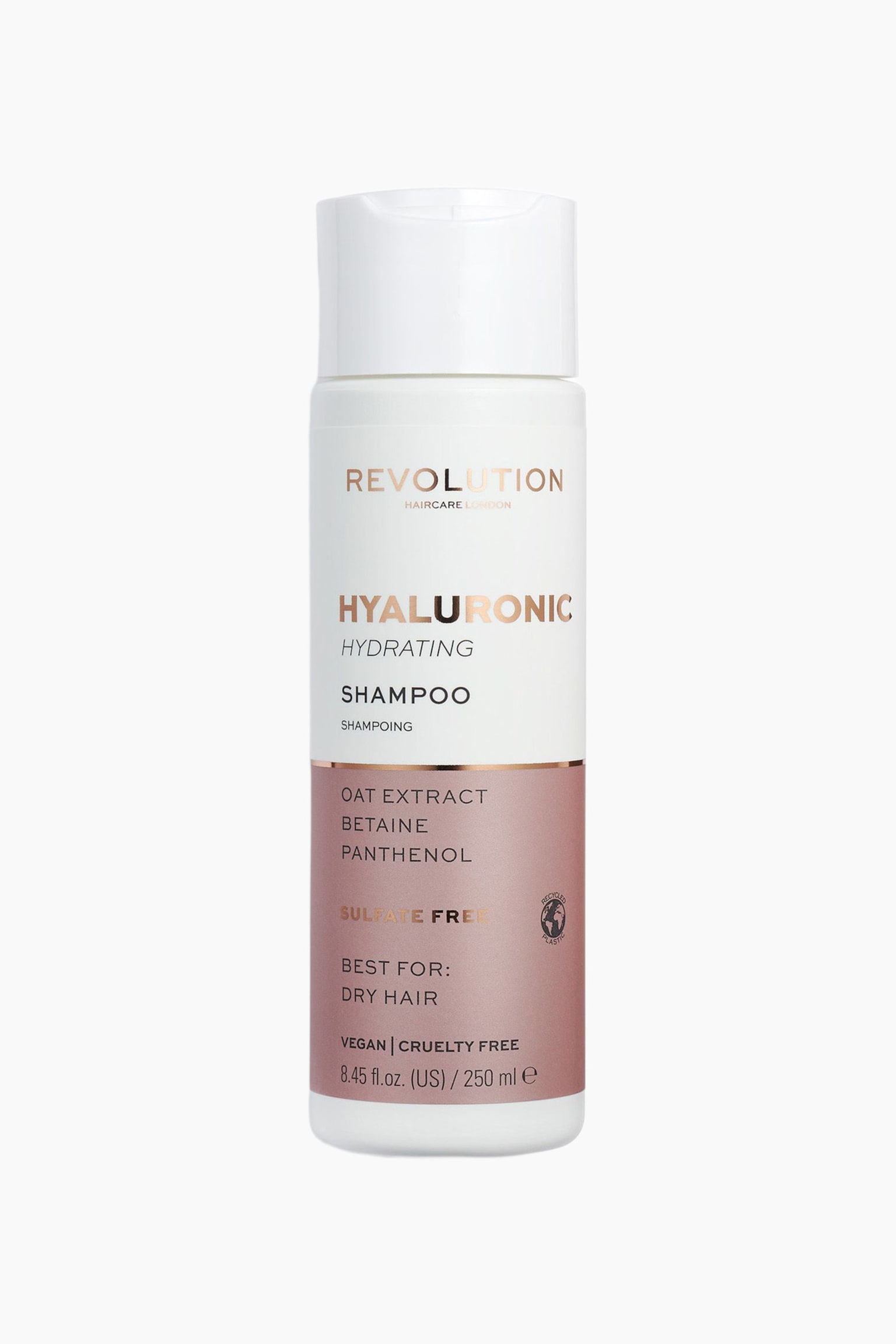 SylinterimÃ¤inen pullo Revolution Haircare Hyaluronic Hydrating Shampoo -shampoota seisoo pystyasennossa. SiinÃ¤ on valkoinen lÃ¤ppÃ¤korkki ja etupuolelle suunnattu etiketti. EtiketissÃ¤ on ruusukullan sÃ¤vyinen metallinhohtoinen teksti valkoisessa ylÃ¤osassa sekÃ¤ pÃ¶lyisen vaaleanpunainen alaosa, jossa on lueteltu keskeiset ainesosat ja tuotetiedot. - 1