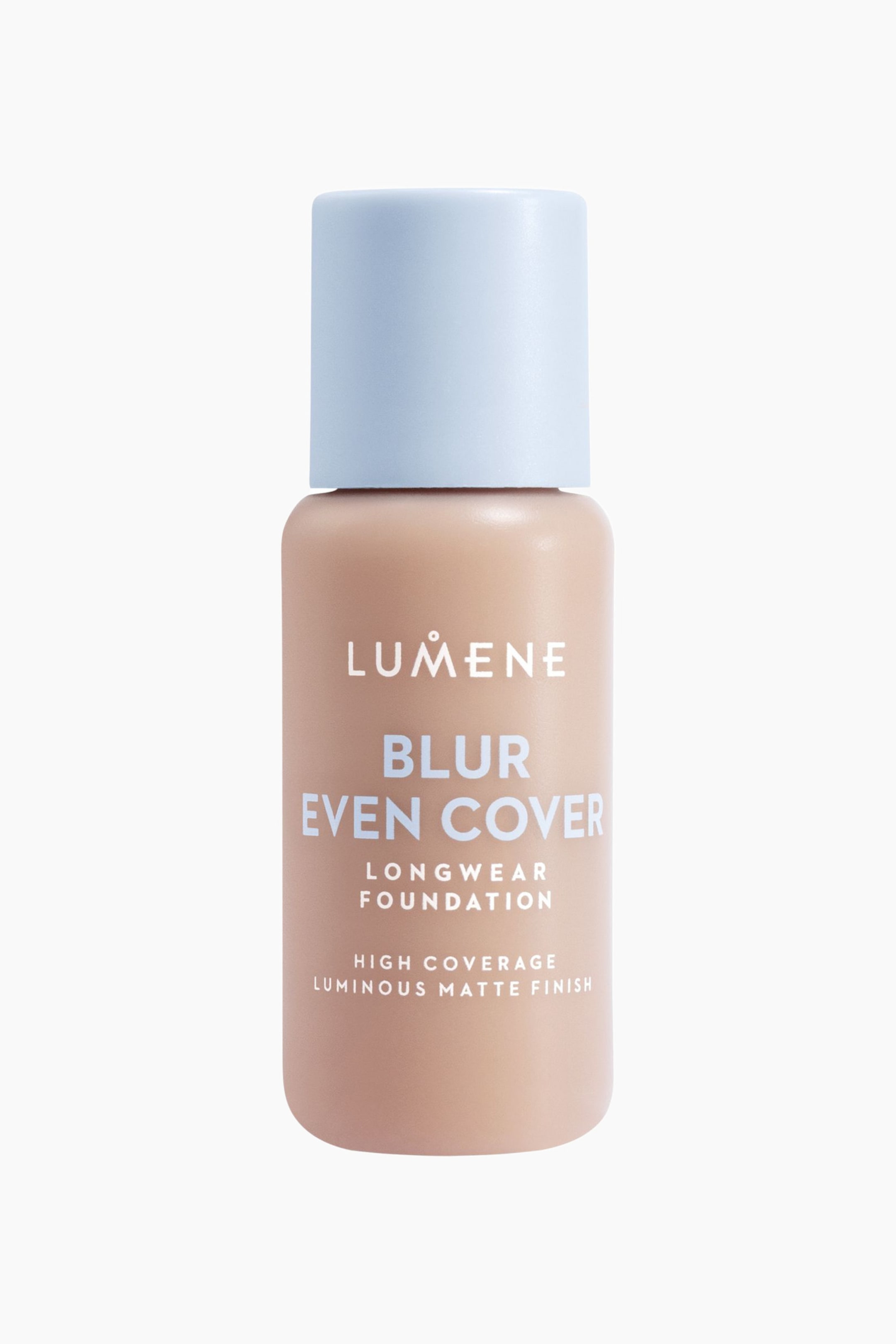 Visa större bild: En Lumene Blur Even Cover Longwear Foundation-flaska står upprätt och visar en ljus persikobeige nyans med ett blekt blått cylinderformat lock. Vit text på flaskan beskriver produkten som "Blur Even Cover Longwear Foundation", "High Coverage" och "Luminous Matte Finish."