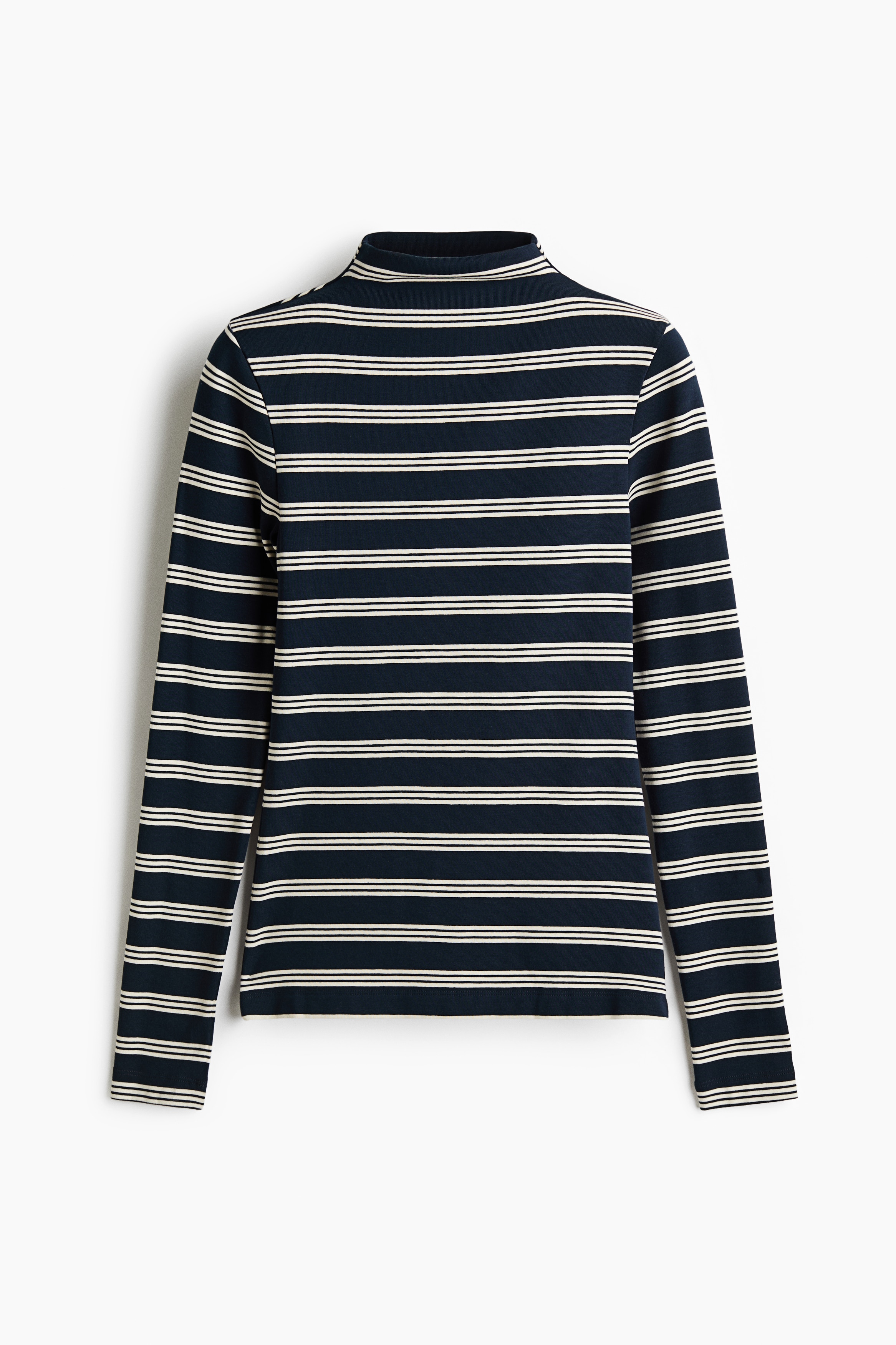 Người mẫu đang mặc một áo jersey ôm dáng với họa tiết sọc ngang xanh navy và trắng, cổ cao và tay dài. Áo được phối cùng quần jeans xanh ống rộng.