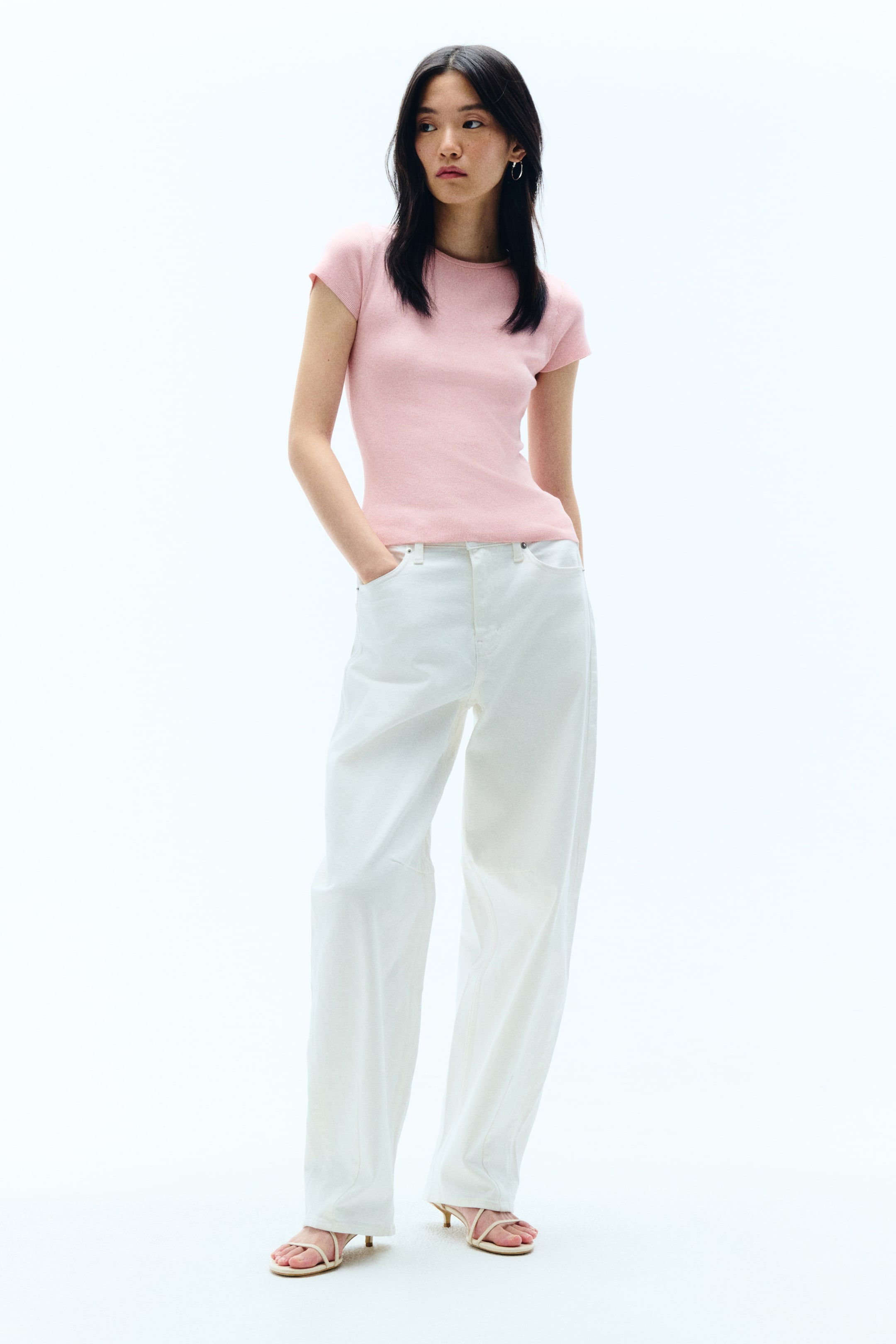 View larger image: A light pink fitted top featuring short cap sleeves and a round neckline. The top showcases a subtle fine-knit texture and fits closely to the torso from the front.