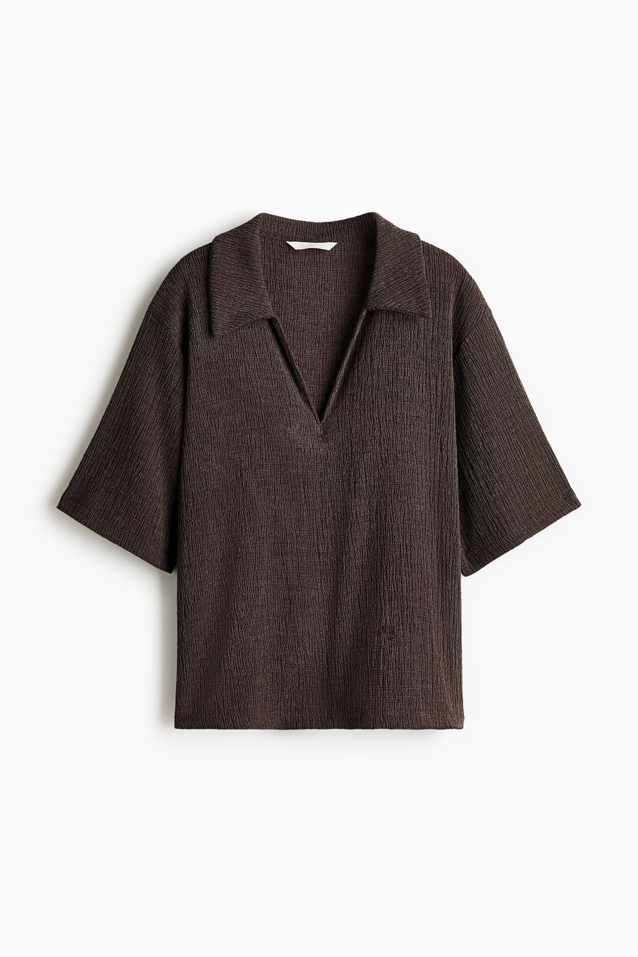 View larger image: A dark brown textured polo shirt is facing front. It features a spread collar, a V-neck opening, and wide, elbow-length sleeves.