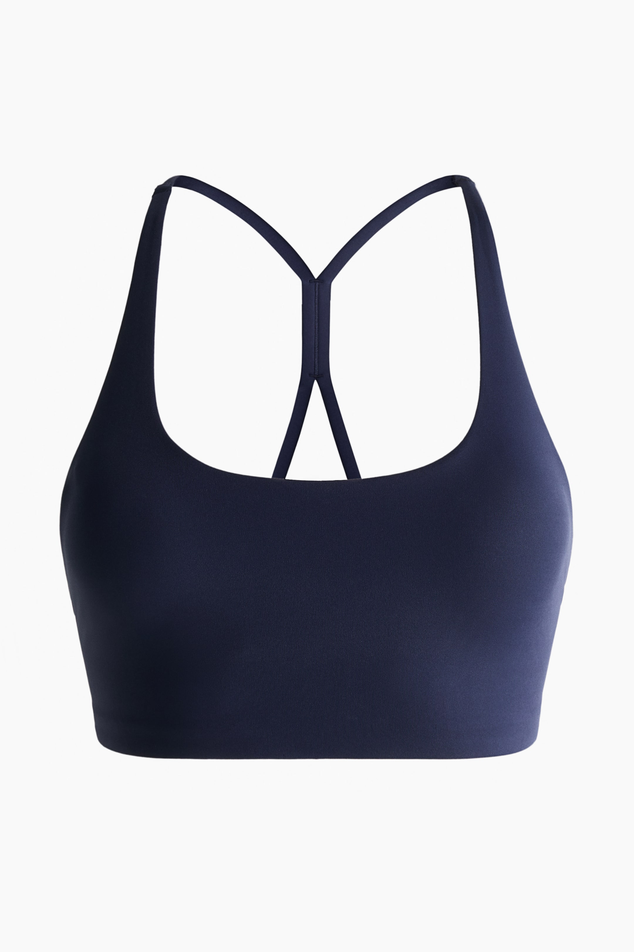 Ingrandisci l'immagine: Reggiseno sportivo a supporto medio con SculptMove? è rivolto FRONTE, appare in colore blu scuro con scollo a barchetta. Le sottili spalline si estendono per formare un design a vogatore visibile nella parte superiore della schiena.