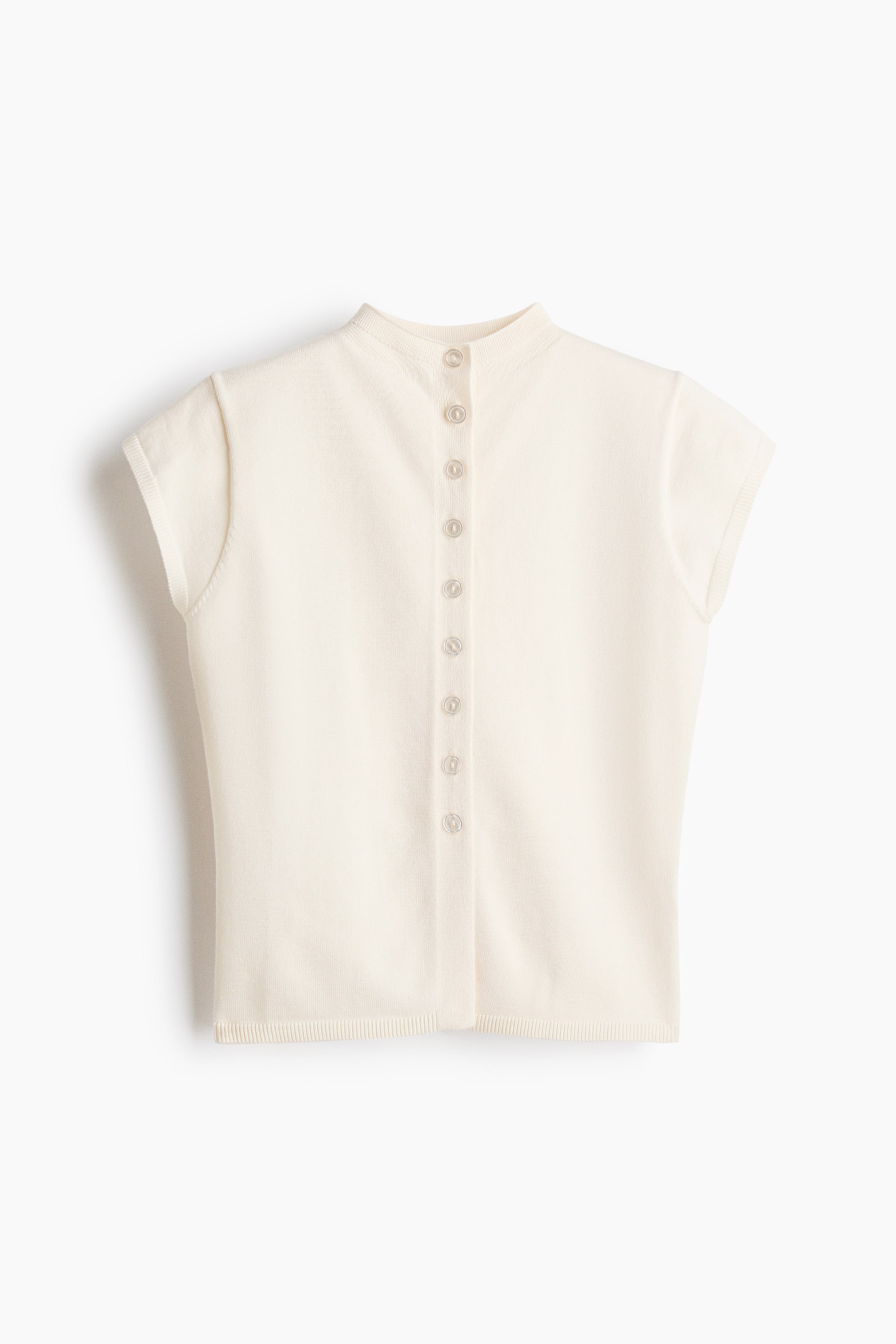 View larger image: A cream knit top featuring a stand collar, cap sleeves, a ribbed hem, and a full button-front closure with small, translucent buttons.