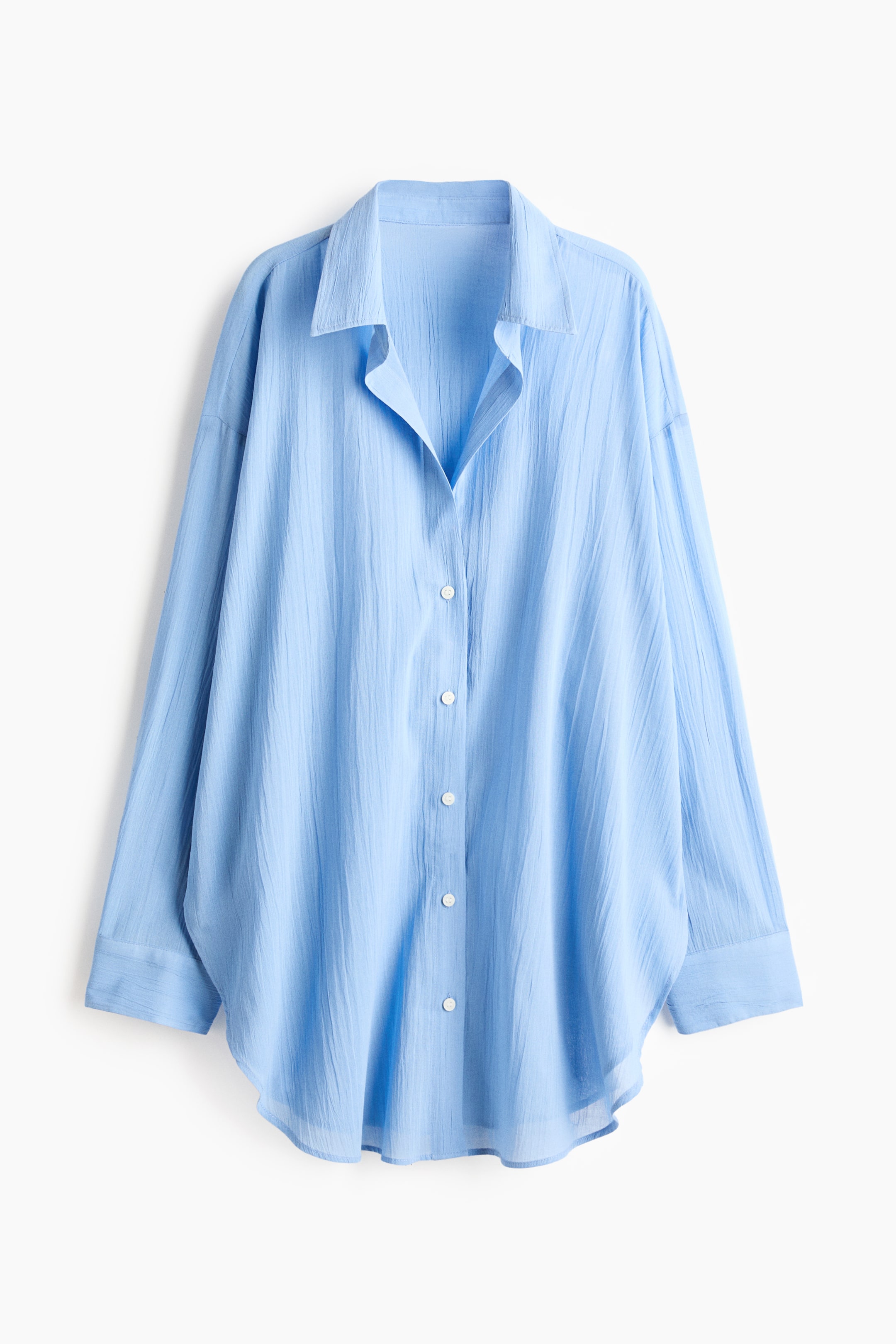 View larger image: A light blue long shirt is showcased from the front, featuring an airy cotton weave, a collar, and buttons down the front. It is crafted with a loose fit, dropped shoulders, long sleeves with buttoned cuffs, and a rounded hem.
