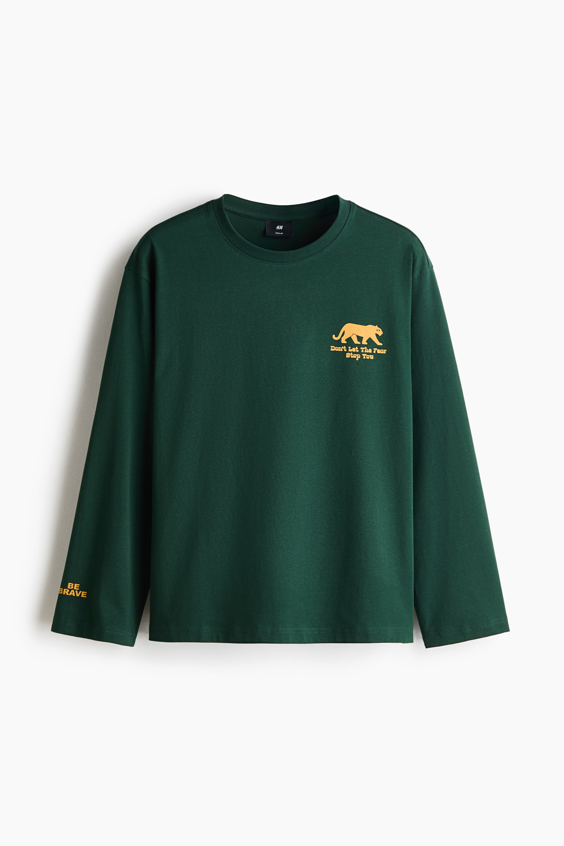 View larger image: A dark green, long-sleeve T-shirt is hanging front-facing, showcasing a round, rib-trimmed neckline, dropped shoulders, and a straight-cut hem. It features a small yellow print on the left chest of a big cat silhouette with the words "Don't Let The Fear Stop You" underneath, along with the text "BE BRAVE" printed on the right sleeve cuff.