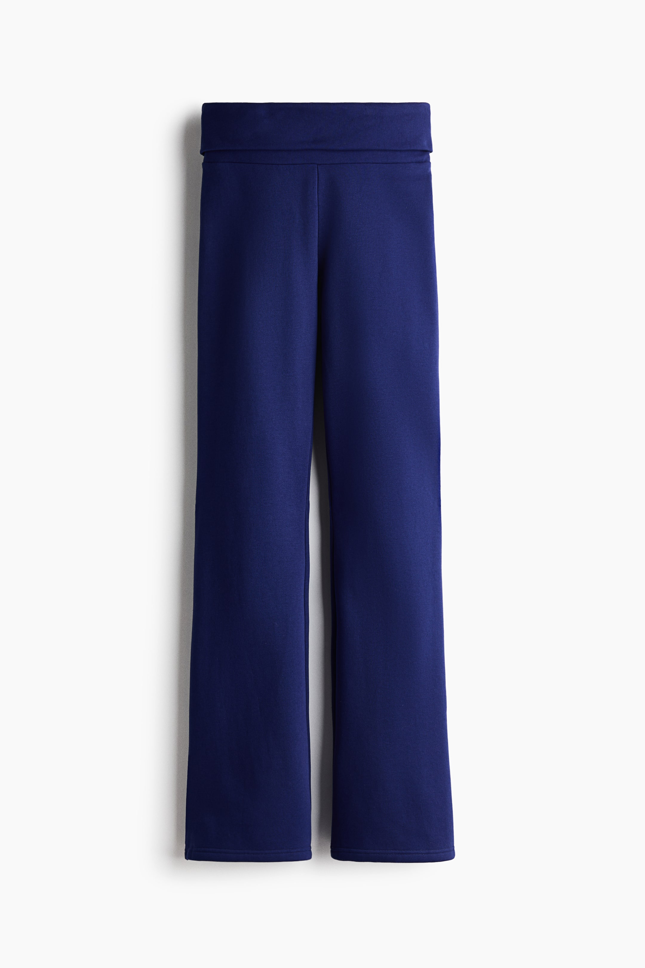 Größeres Bild anzeigen: Ein Paar marineblaue Strickhosen ist von vorne zu sehen und verfügt über einen breiten, umgeschlagenen Bund sowie eine gerade Beinform. Die Hose hängt senkrecht und zeigt eine glatte Textur mit nur wenigen sichtbaren Nähten.