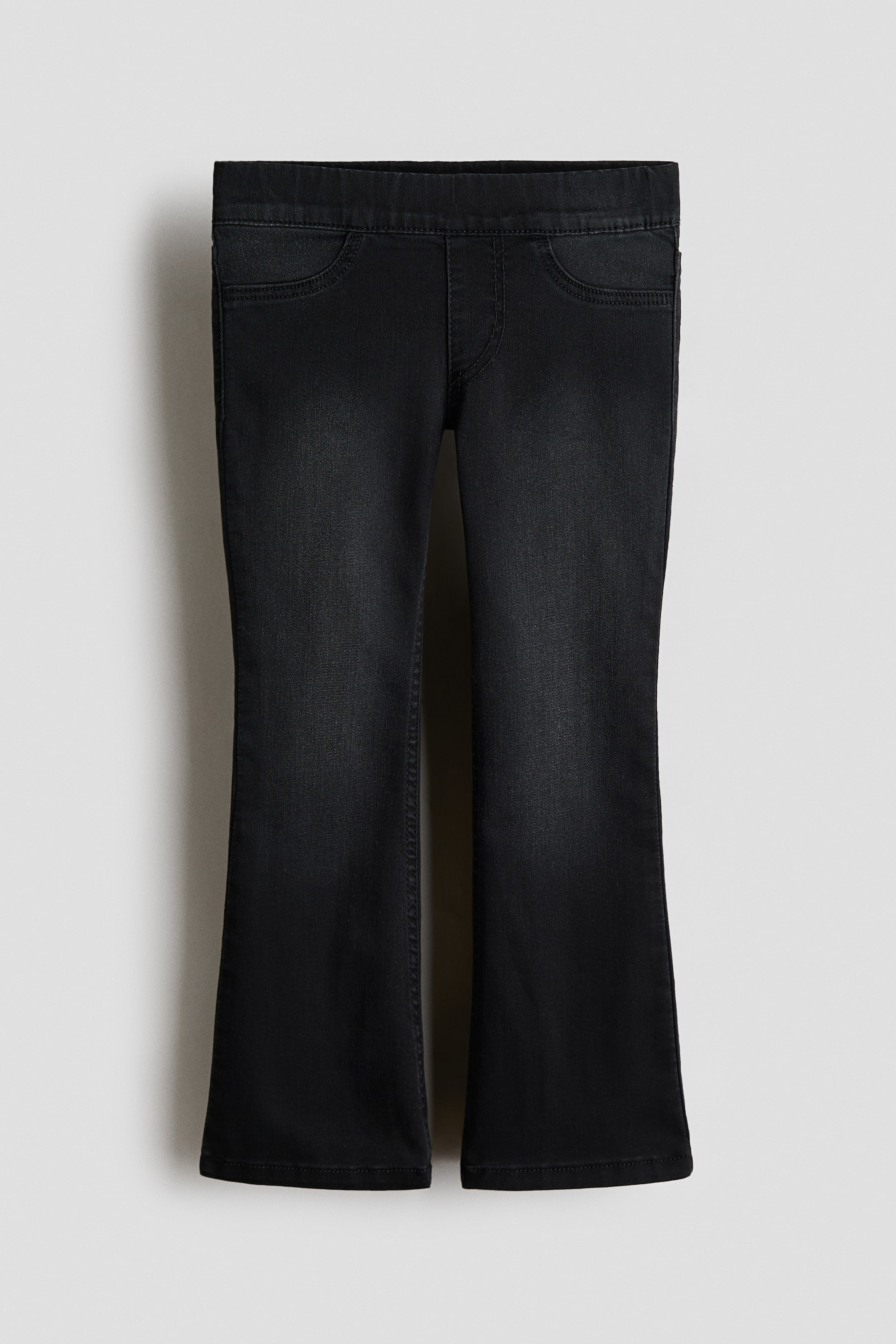 Visualizza l'immagine ingrandita: I jeans neri presentano un lavaggio sbiadito, progettati con una vestibilità aderente su fianchi e cosce e che si allargano in gambe ampie. Sono caratterizzati da una vita elasticizzata coperta, una patta finta cucita e finte tasche frontali cucite.