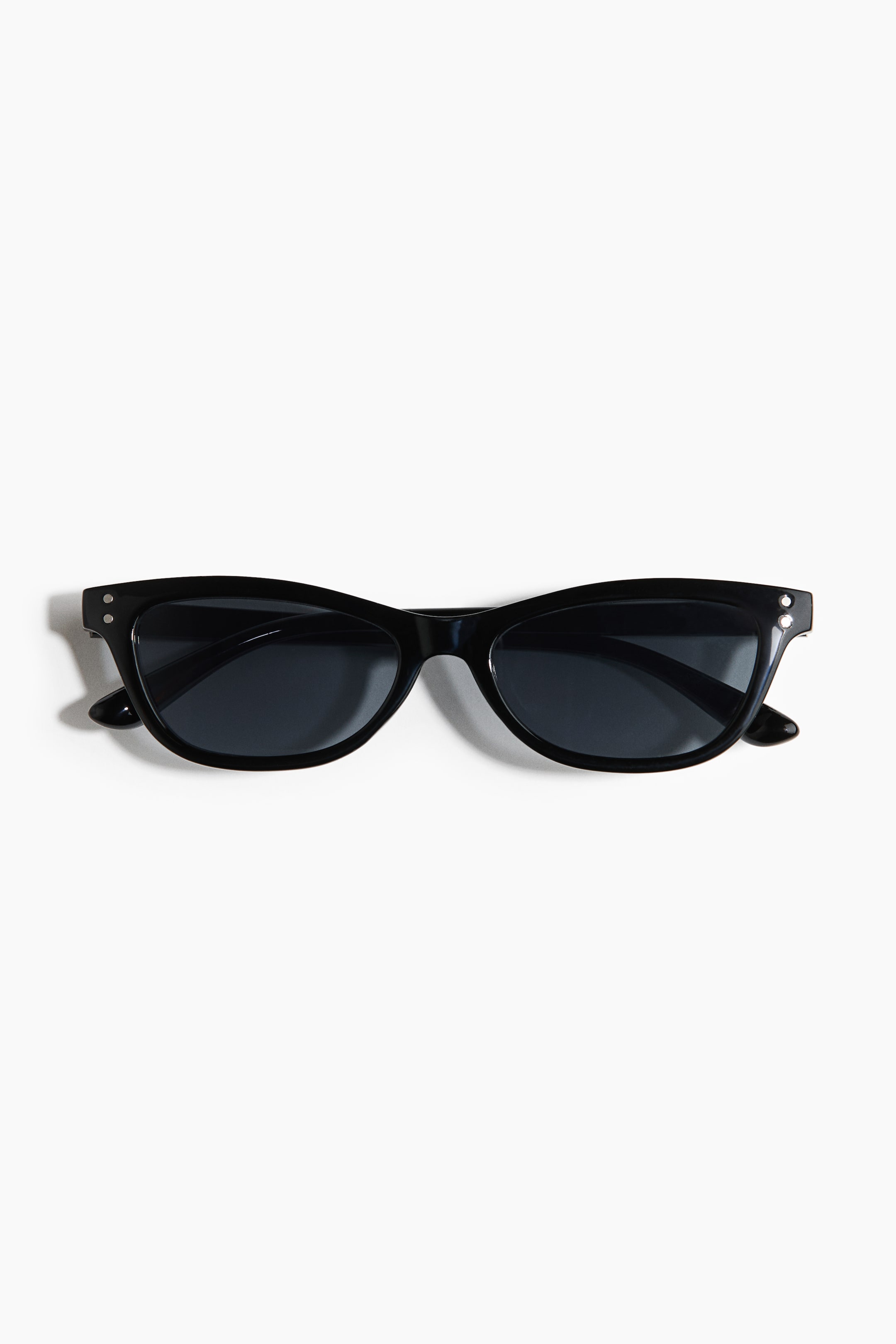 View larger image: Black cat-eye sunglasses feature dark lenses and small silver-toned circular studs detailing the outer corners of the frame.