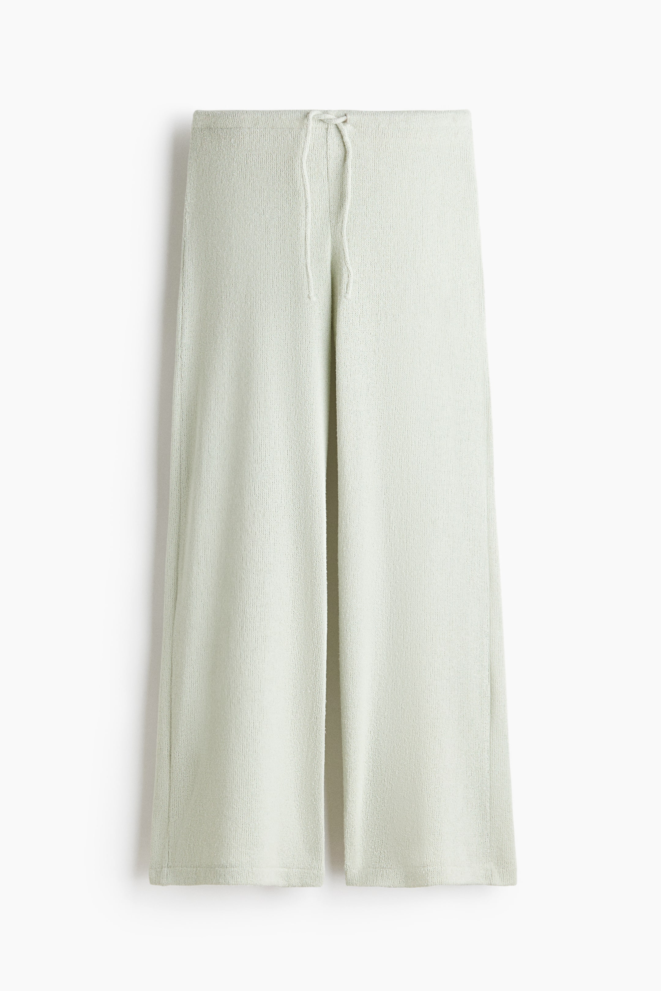 View larger image: "Light green knitted trousers feature an elasticated, drawstring waist and wide legs, showcased from the front."