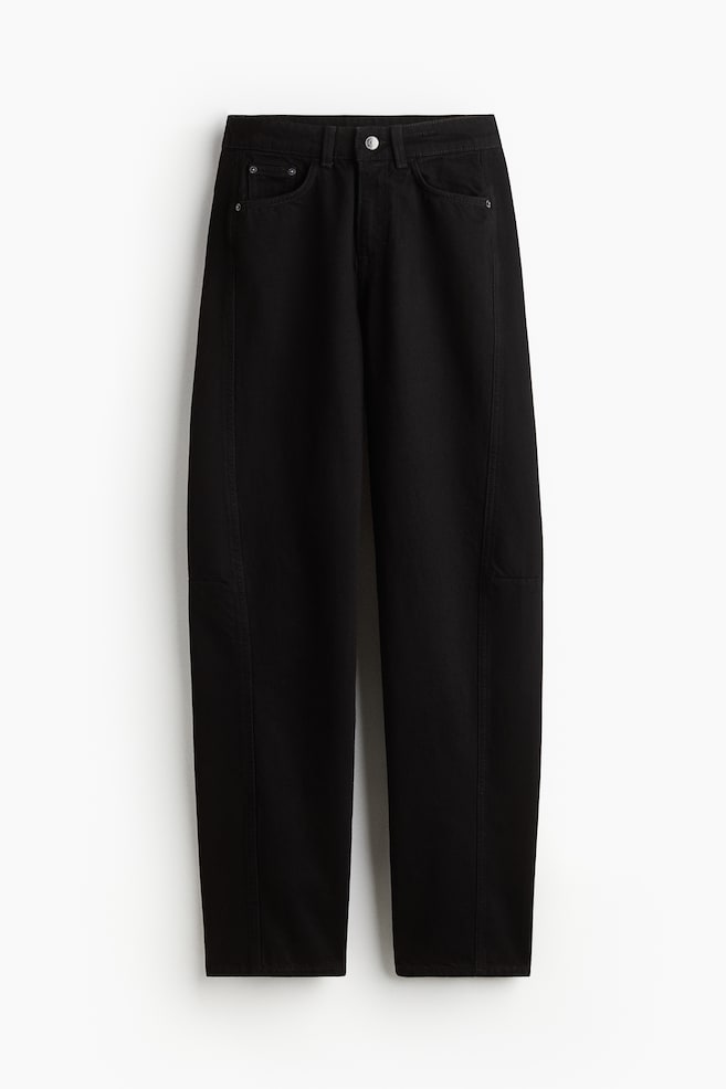 Black 5-pocket jeans in rigid cotton denim are presented from the front, featuring a regular waist secured by a button and zip fly. Their wide legs are showcasing tone-on-tone side panels with a knee dart, which is adding volume and contributing to a longer length. - 1