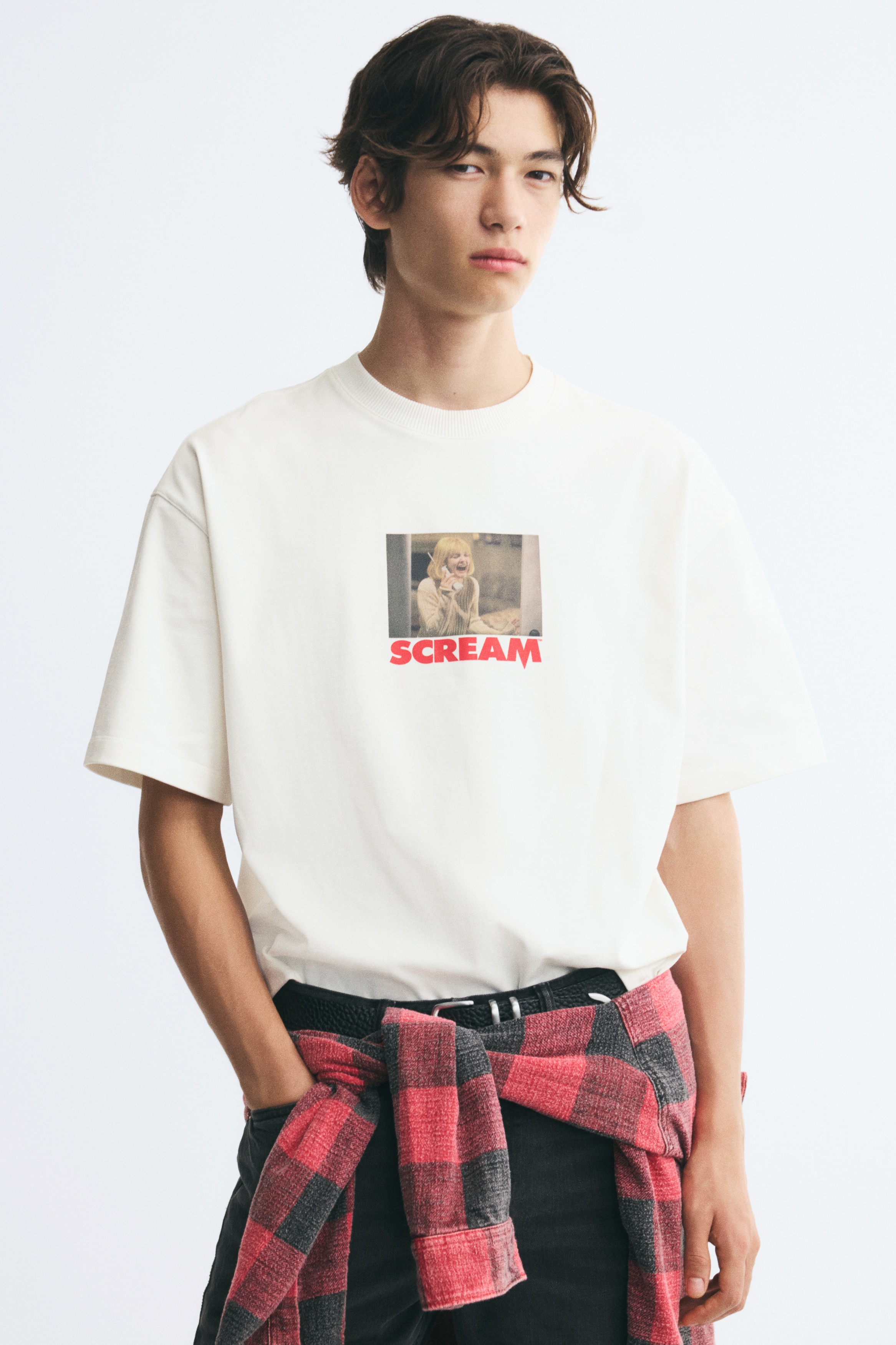 ä¸ä»¶ç±³ç½è²å¯¬é¬çå T æ¤ä»¥åè¦è§å±ç¤ºï¼è¨­æç¾ç´åé åå¯¬èº«ç­è¢ãè¸åå°æä¸åå°åé·æ¹å½¢é»å½±å ´æ¯åæ¡ï¼æ­£ä¸æ¹ä»¥ç²é«ç´è²å­æ¨£ç´æ¥å°ä¸ãSCREAMãå­æ¨£ã