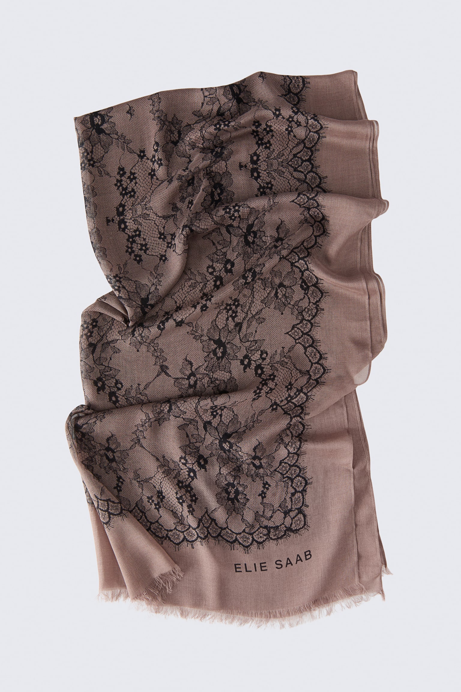 Der Schal aus Seidenmischung im Jacquard-Gewebe fÃ¤llt vertikal in weichen Falten und zeigt ein zartes schwarzes florales Spitzen-Jacquard-Muster, das sich Ã¼ber den altrosafarbenen Stoff zieht. Die untere Kante ist mit Fransenabschluss versehen und trÃ¤gt den in Schwarz aufgedruckten Markennamen âELIE SAABâ.